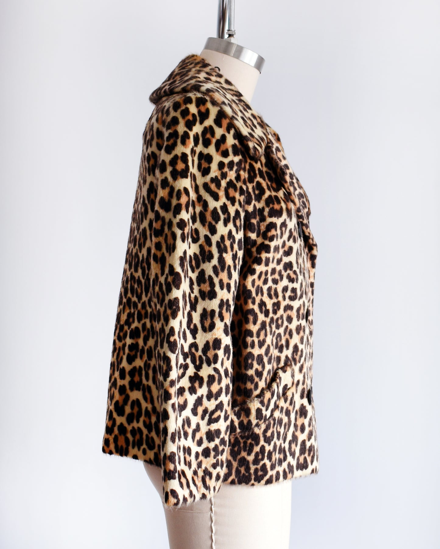 side view of a vintage 1960s leopard print jacket on a mannequin against a white background