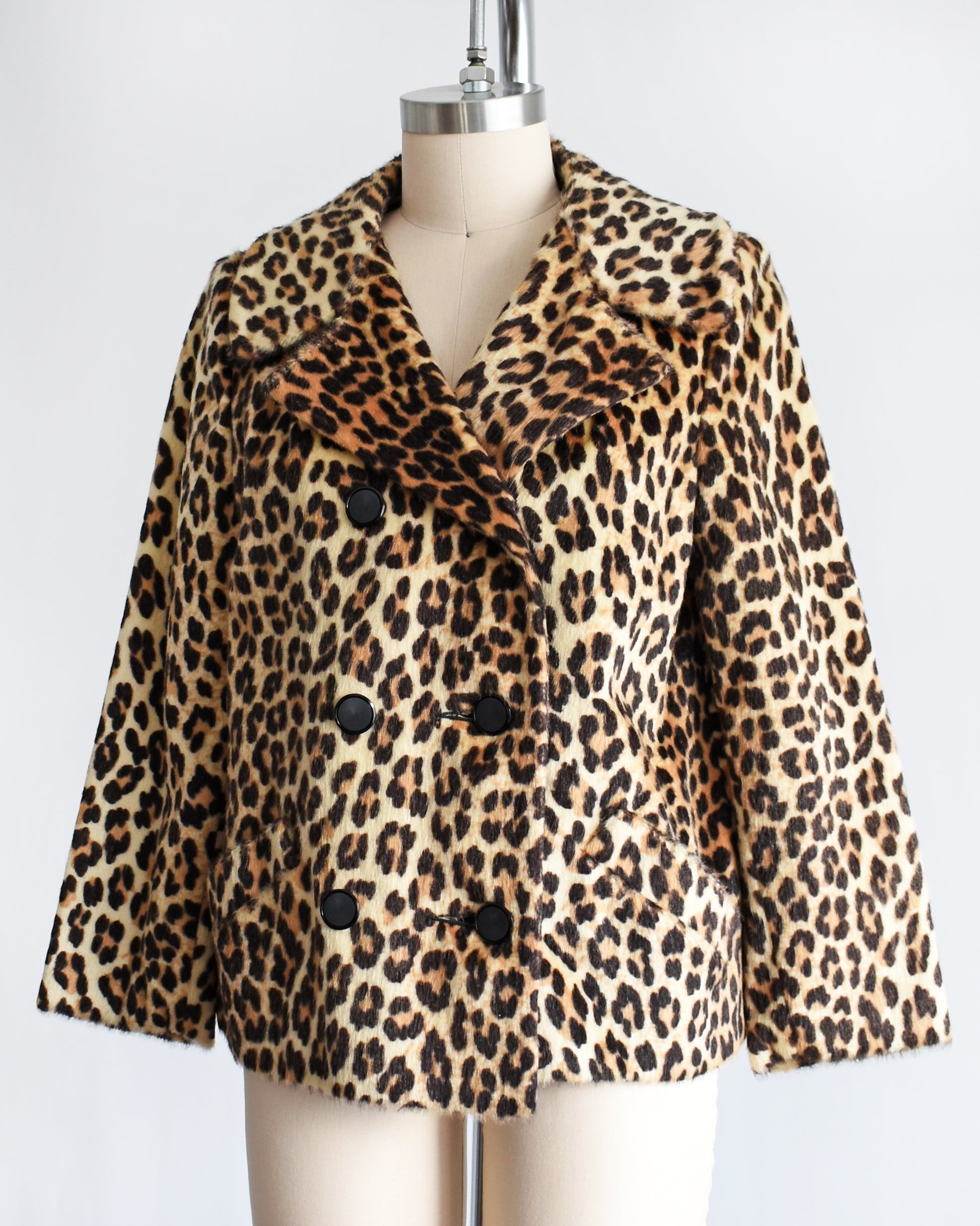 side front view of a vintage 1960s leopard print jacket on a mannequin against a white background