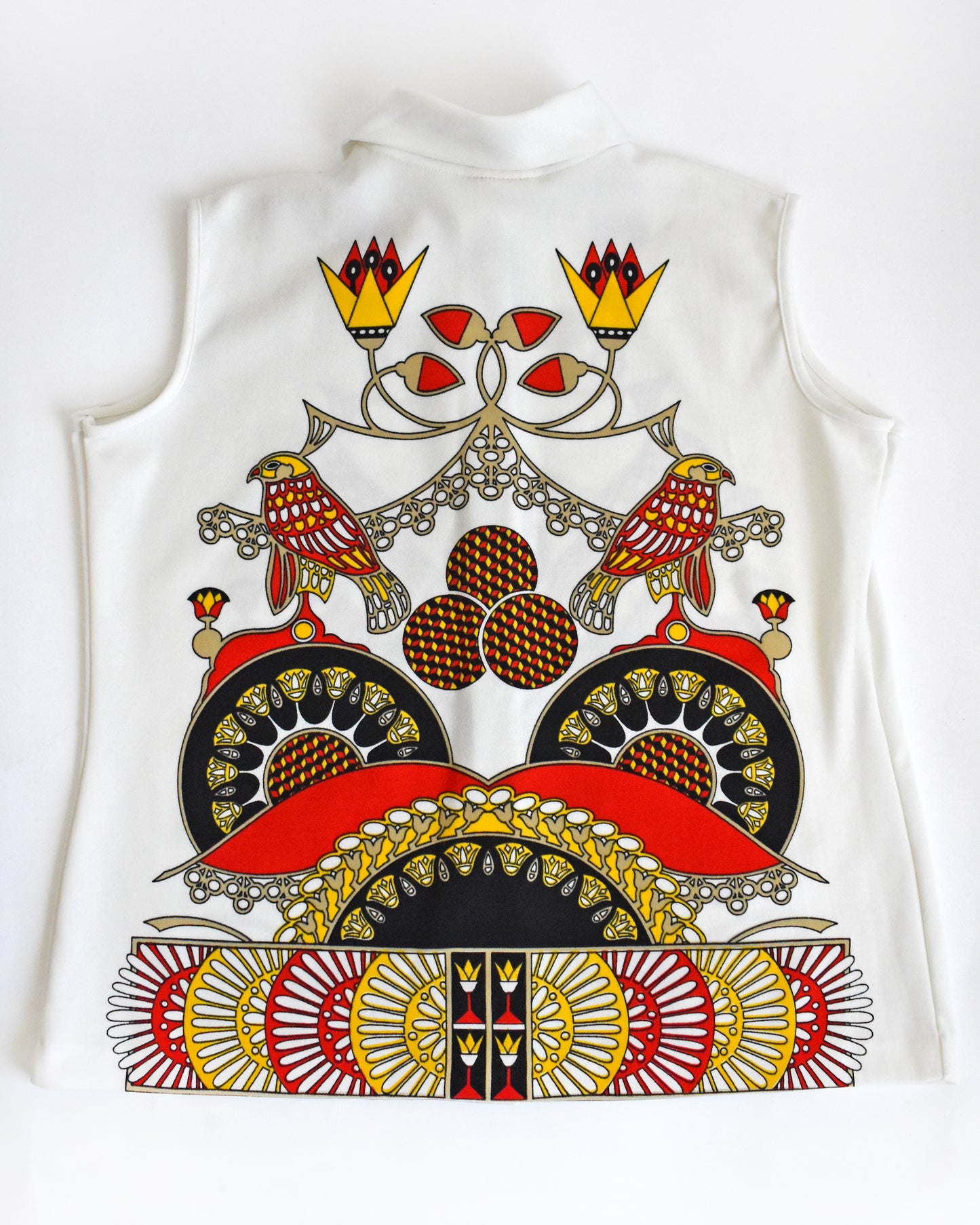 the back of a vintage 1970s white sleeveless top with a colorful abstract bird design on a white background
