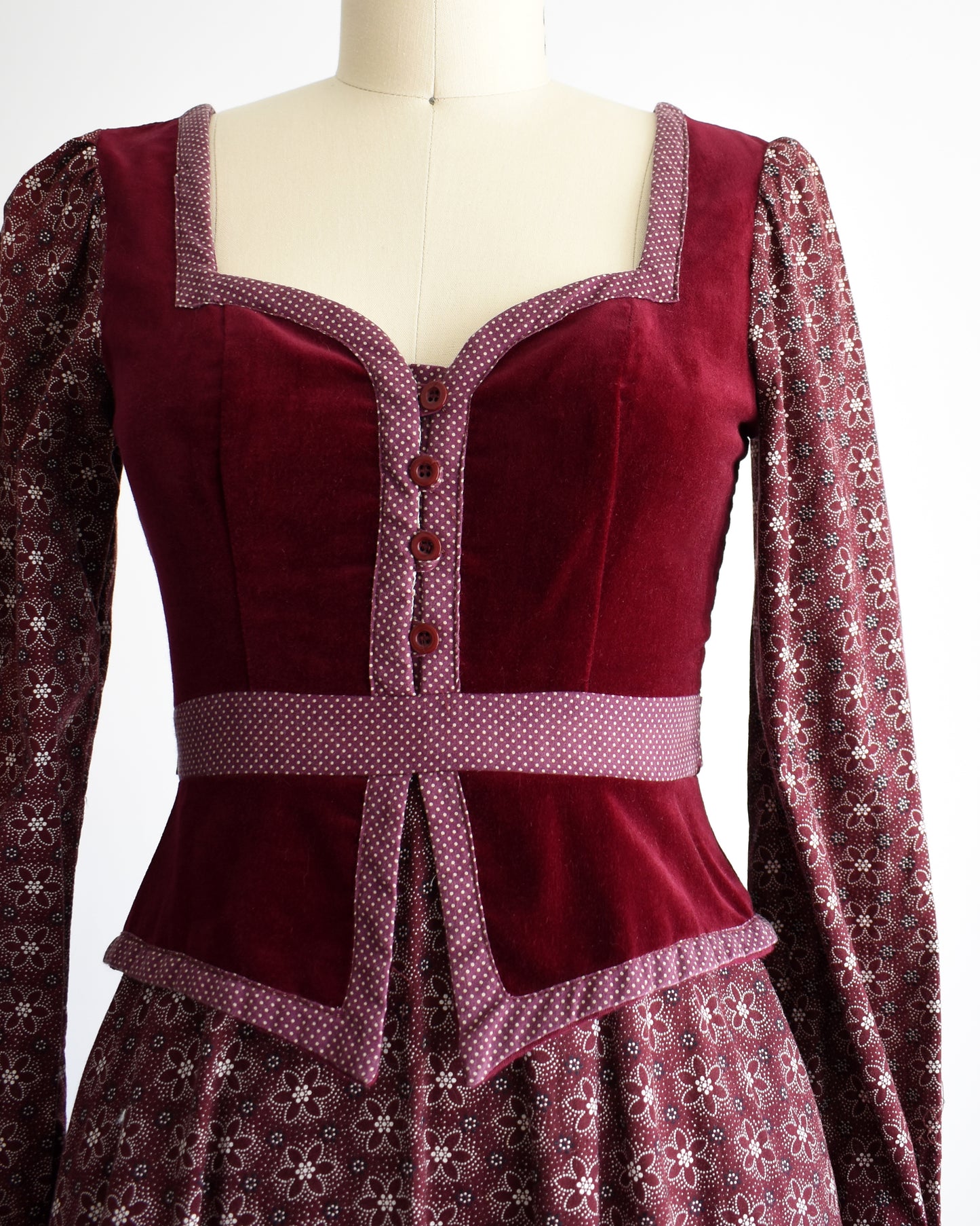 close up of the velvet bodice with polka dot trim and floral sleeves of the vintage 1970s Gunne Sax dress