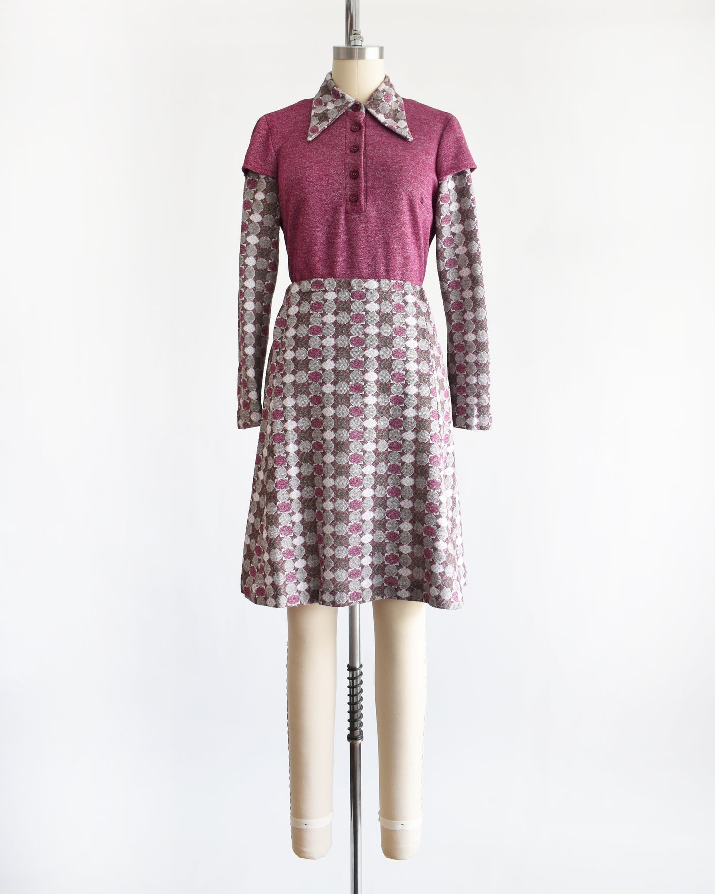 a vintage 1970s dress set that has a purple top and patterned skirt on a mannequin against a white background