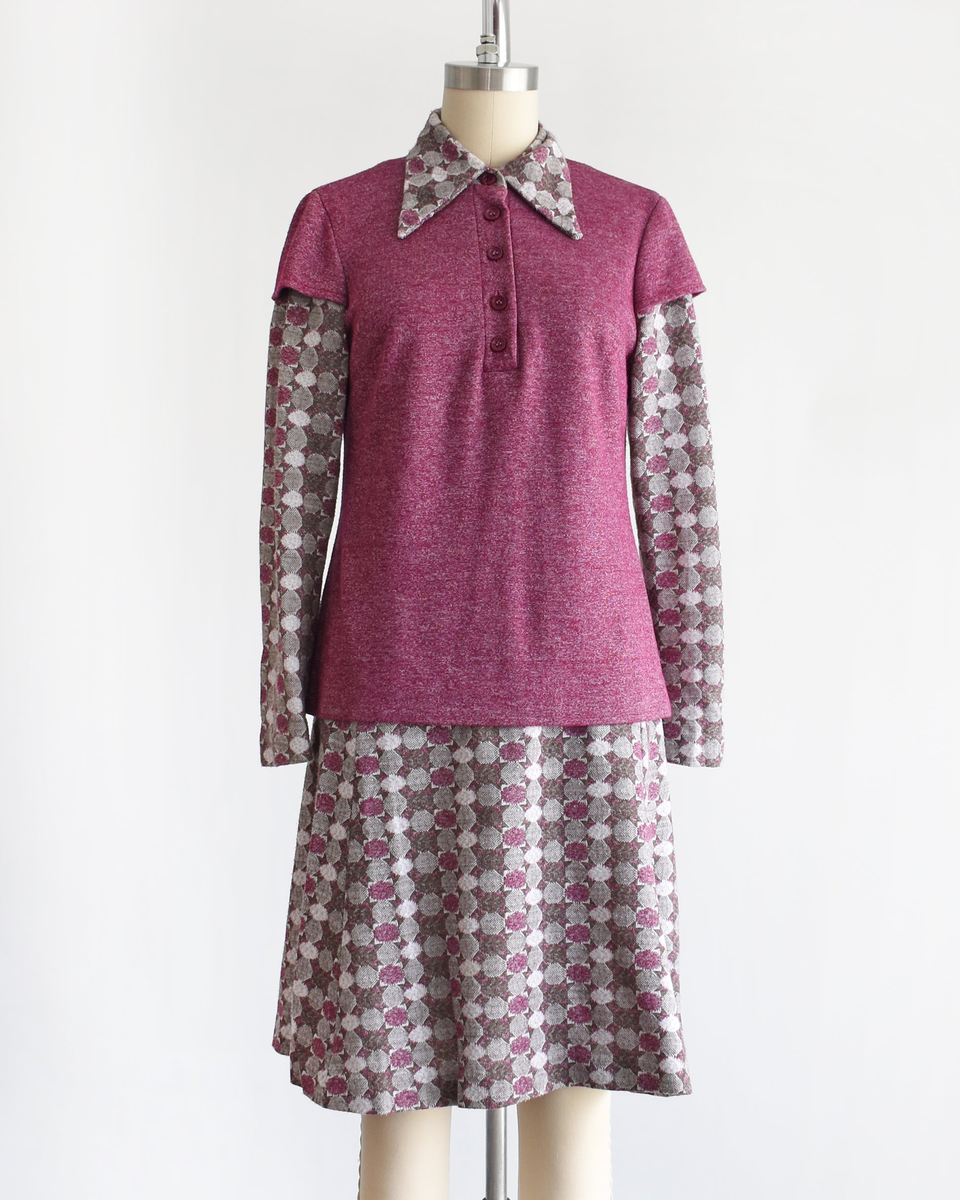 a vintage 1970s dress set that has a purple top and patterned skirt on a mannequin against a white background. the top is untucked in the photo.