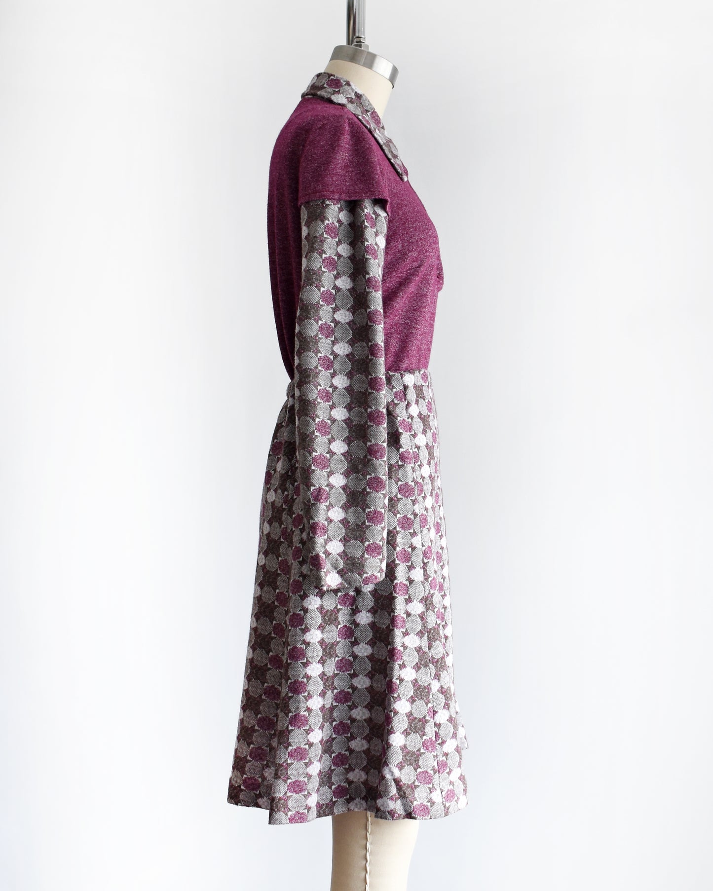 side view of a vintage 1970s dress set that has a purple top and patterned skirt on a mannequin against a white background