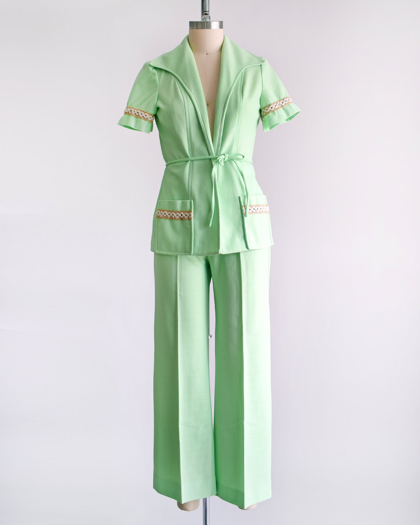 a vintage 1970s mint green pantsuit that has a matching blazer, a tie belt, and wide leg pants