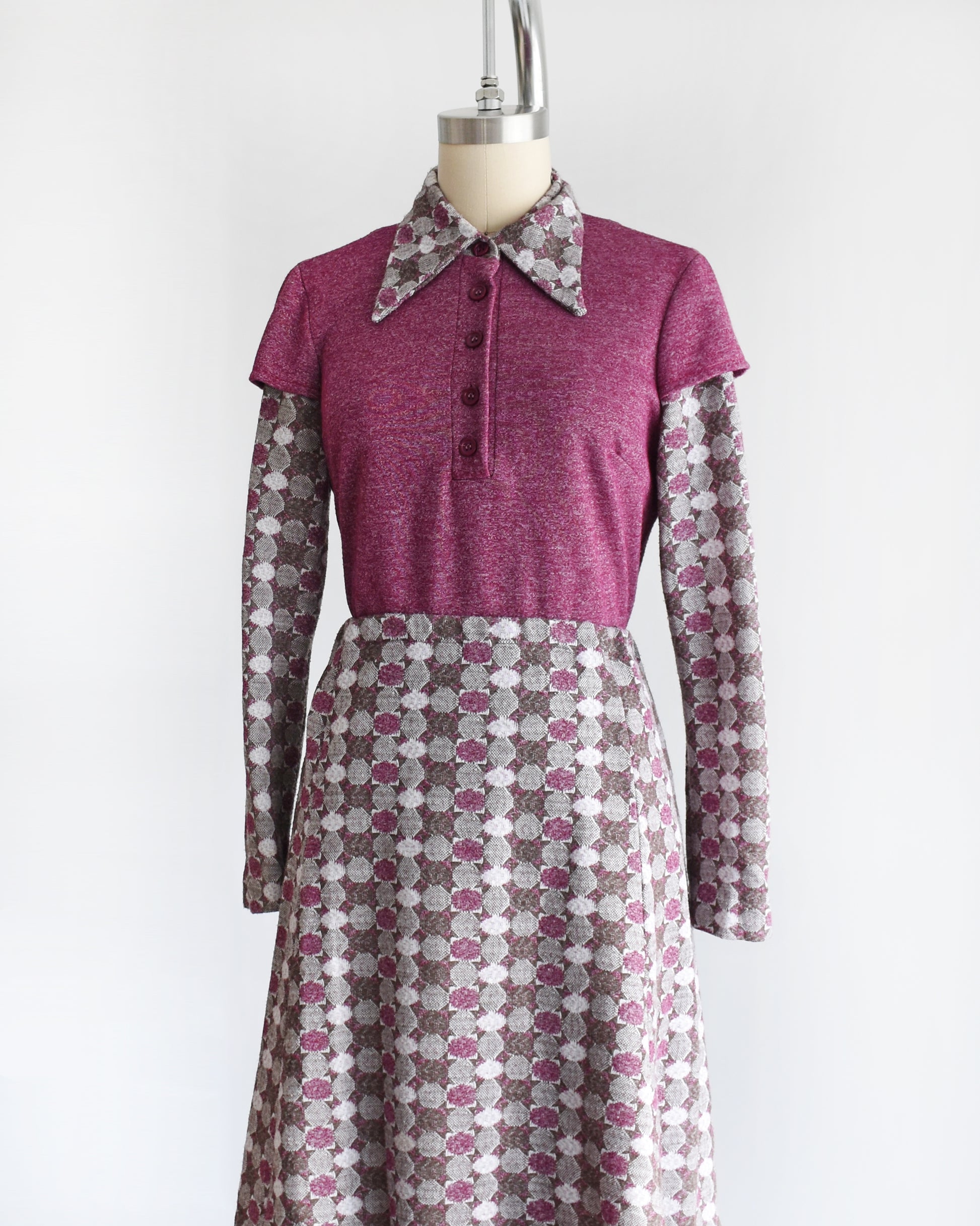 a vintage 1970s dress set that has a purple top and patterned skirt on a mannequin against a white background. 