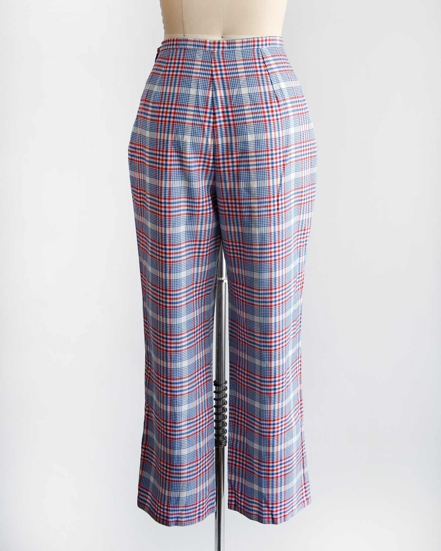 back view of vintage 1970s red white and blue plaid pants on a dress form