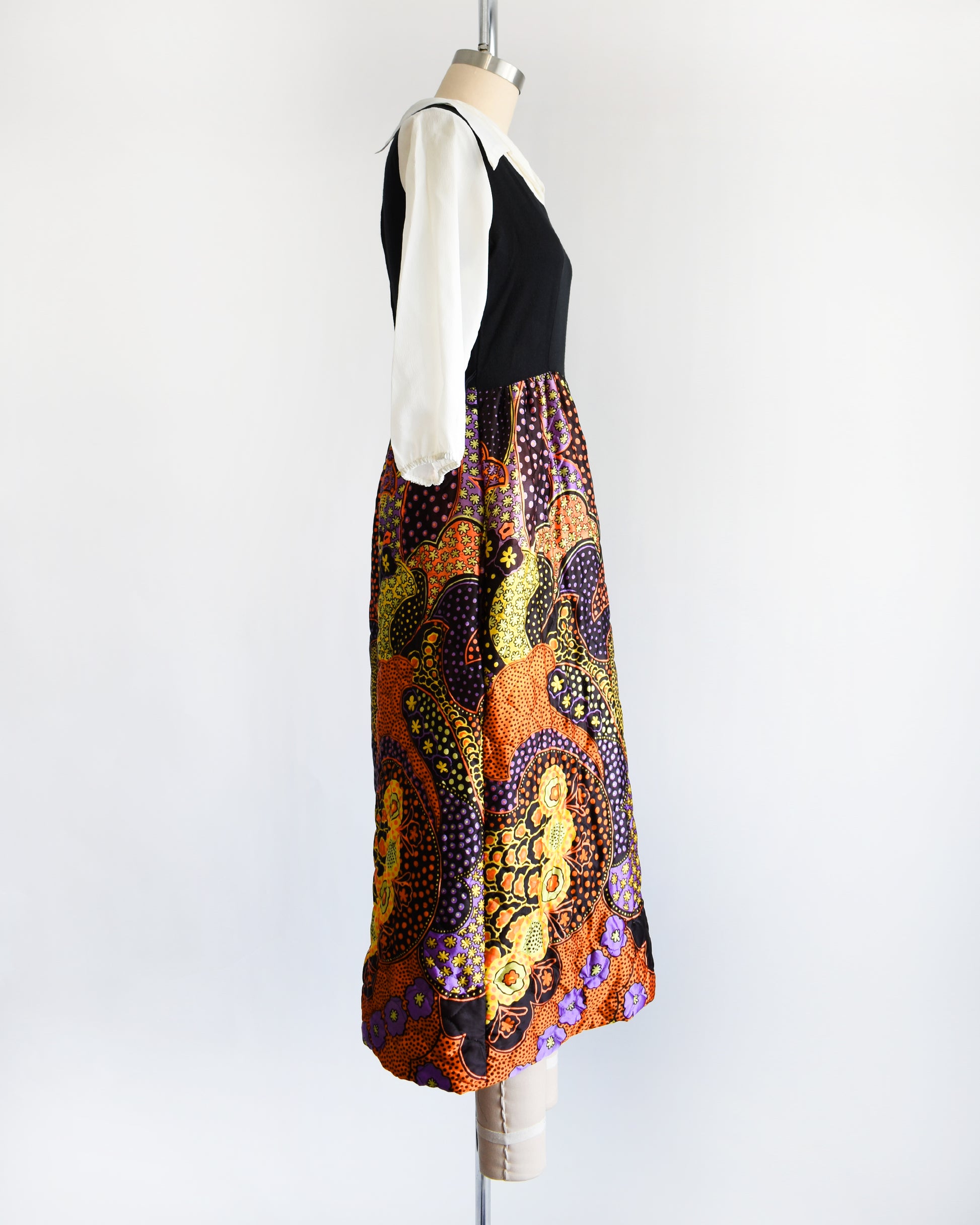 side view of a vintage 1970s psychedelic quilted maxi dress on a mannequin against a white background