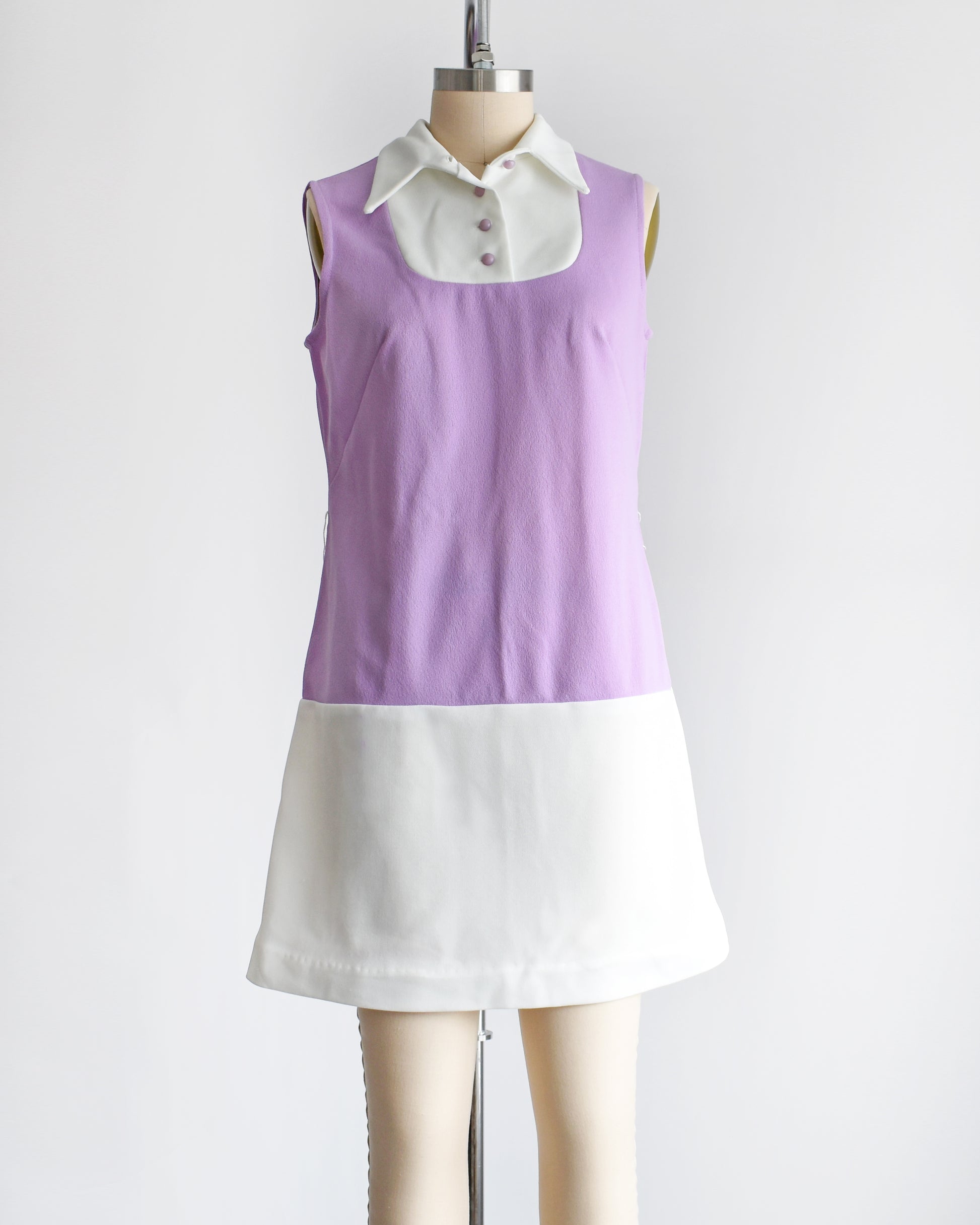 a vintage 1960s purple and white mod mini dress. the belt is missing from the dress