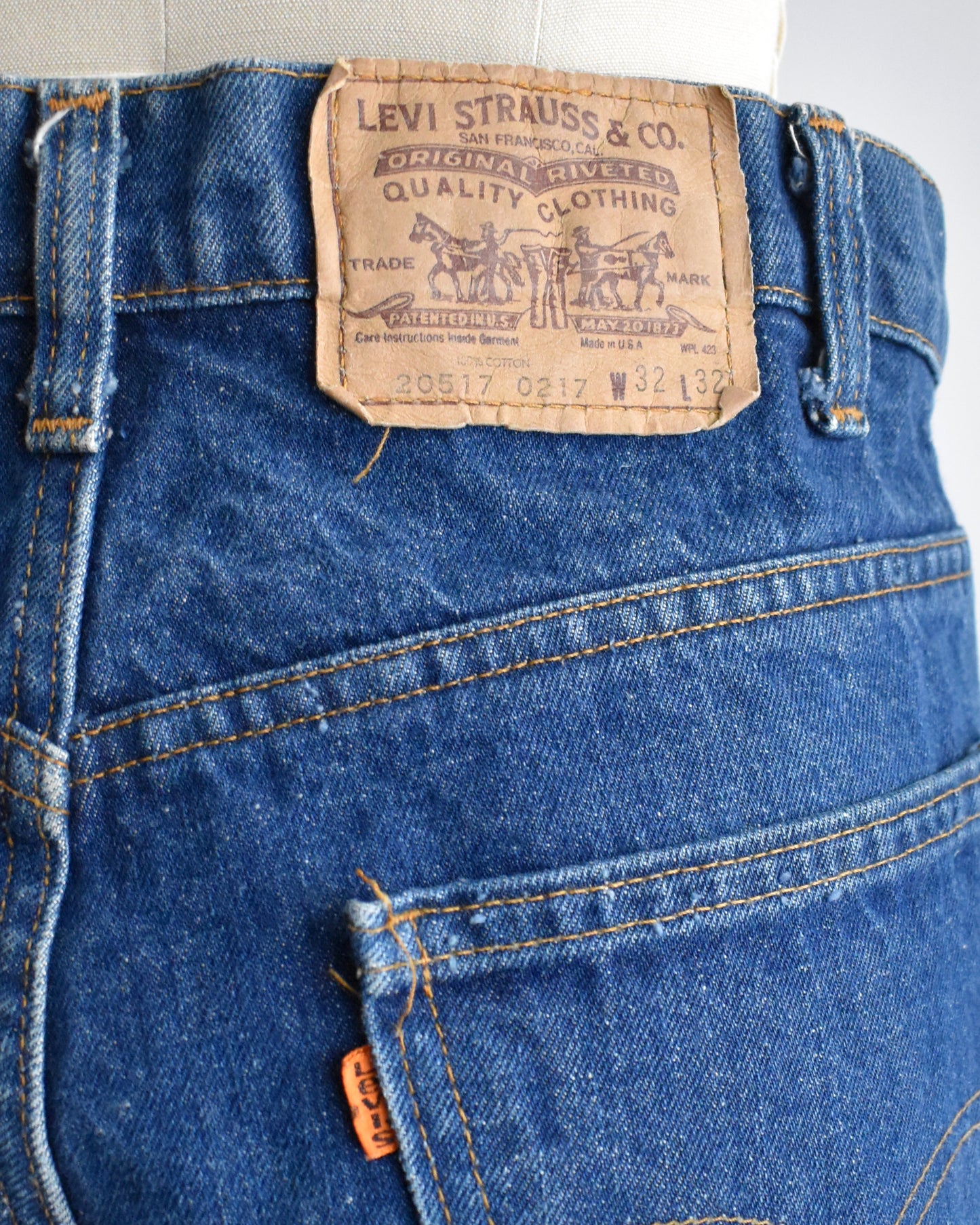 Close-up of Levi Strauss & Co. jeans with a brand label on a white background