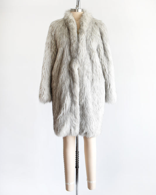 a vintage 1980s faux fur silver fox coat on a dress form on a white background