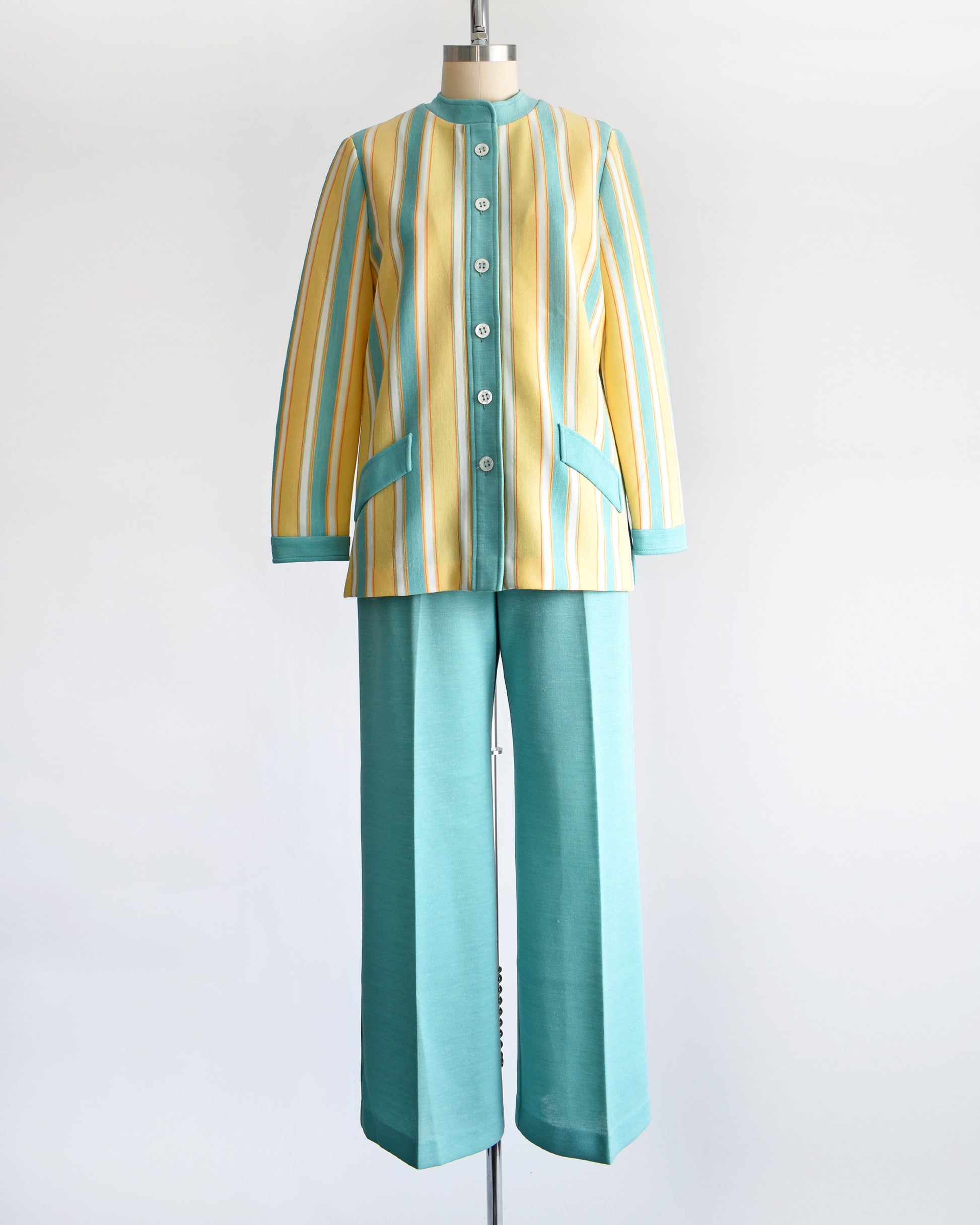 A vintage 1970s two piece pantsuit. The top is yellow, blue, white and orange striped, and the pants are the same matching blue.