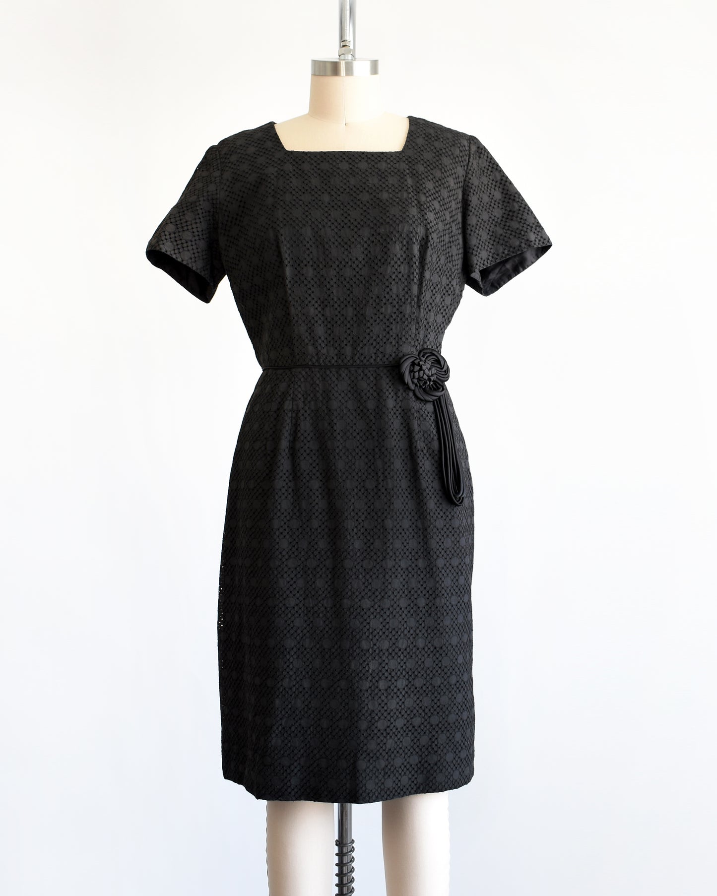 a vintage 1960s black eyelet dress on a mannequin on a dress form