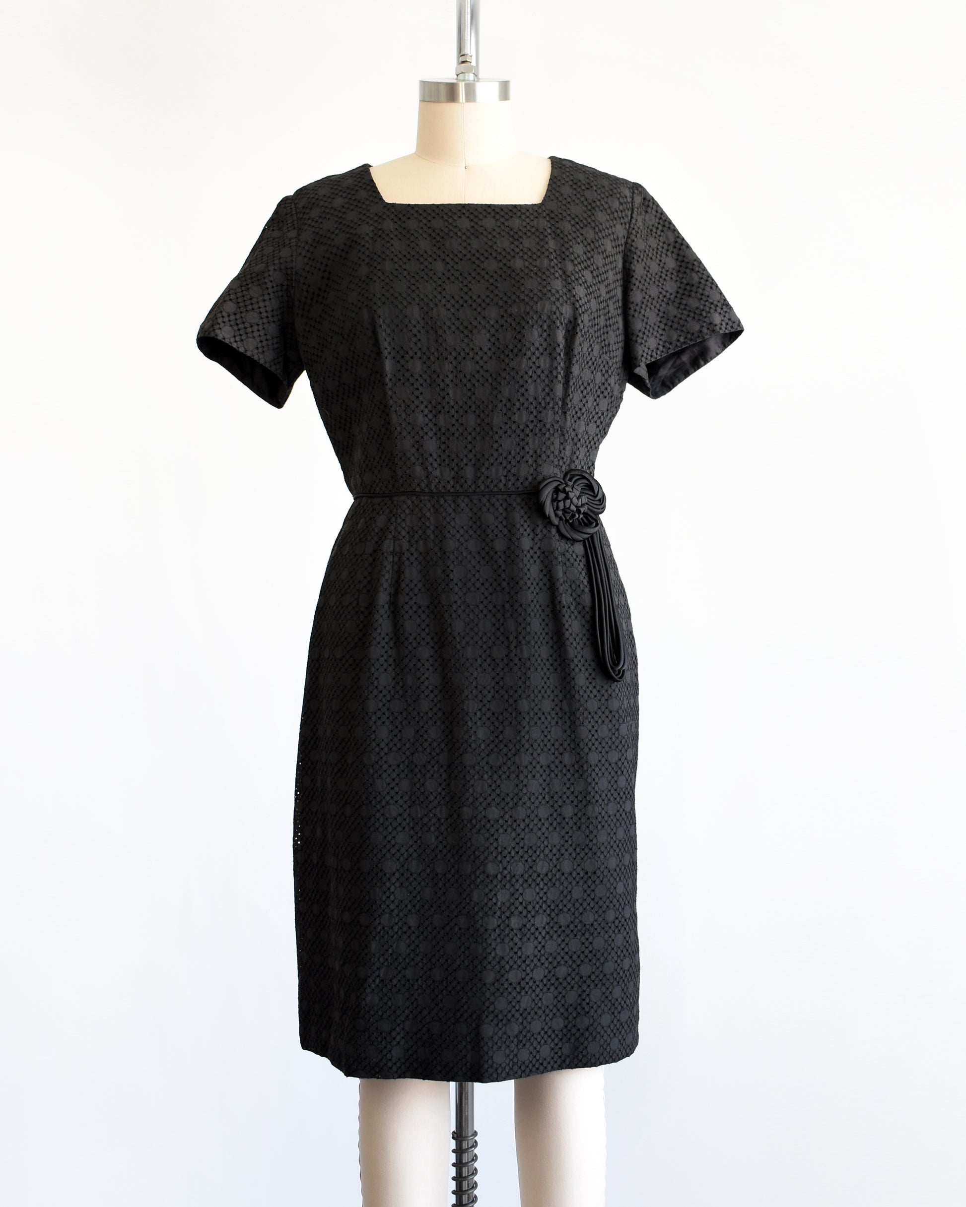 a vintage 1960s black eyelet dress on a mannequin on a dress form