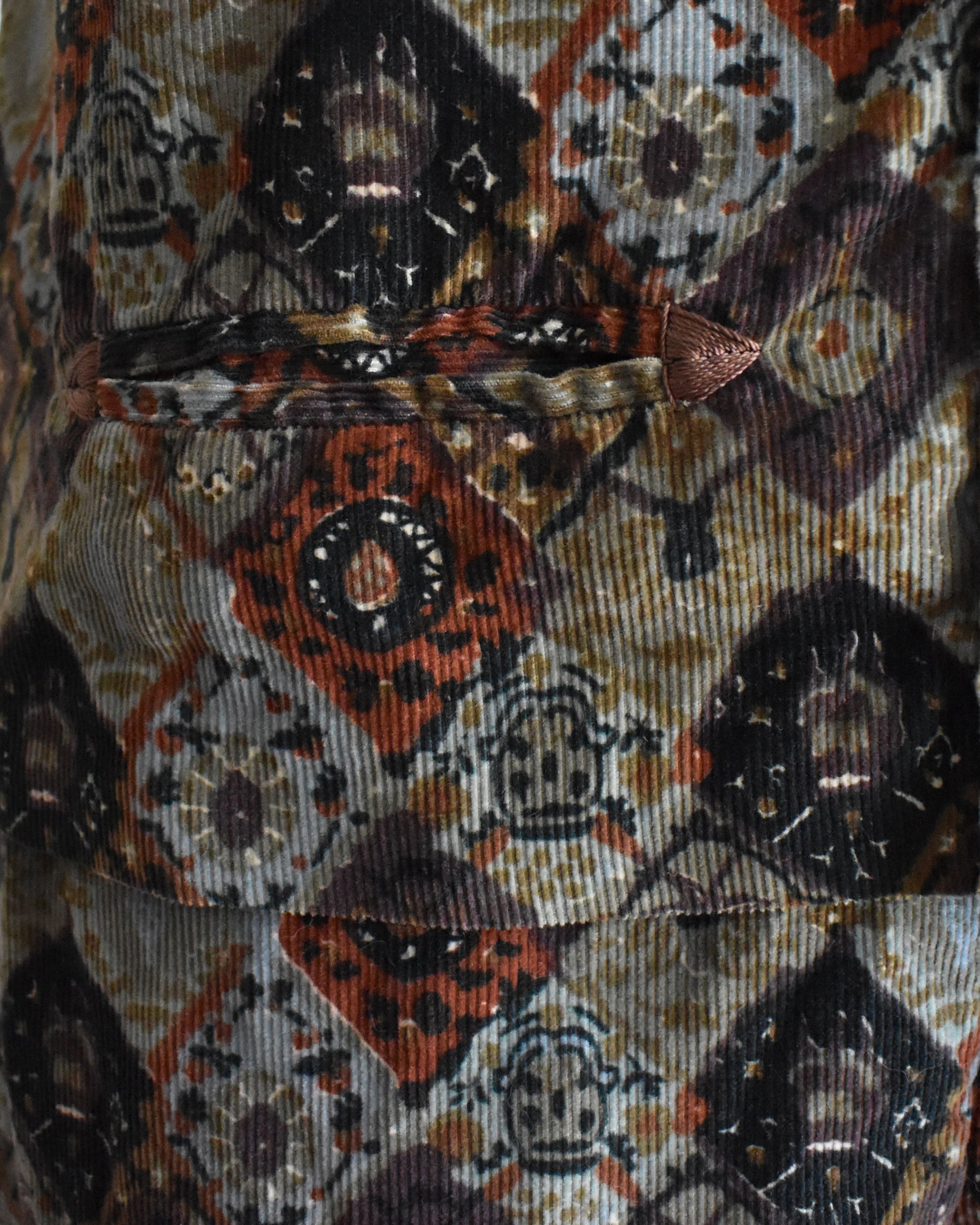 close up of the small pocket with embroidered corners on a vintage 1960s floral patterned vest 