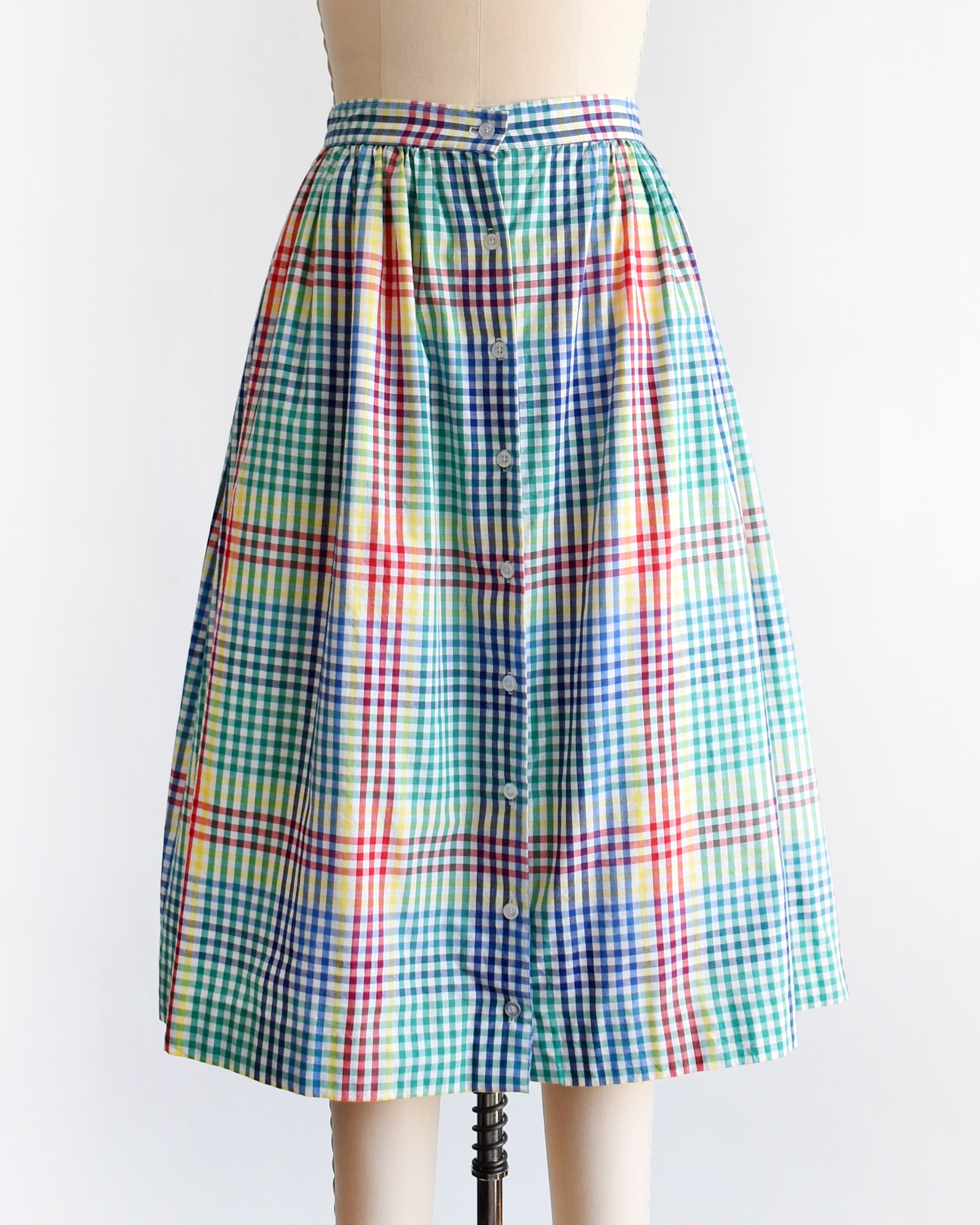a vintage 1980s multicolor plaid midi skirt displayed on a beige dress form mannequin against a plain white background.