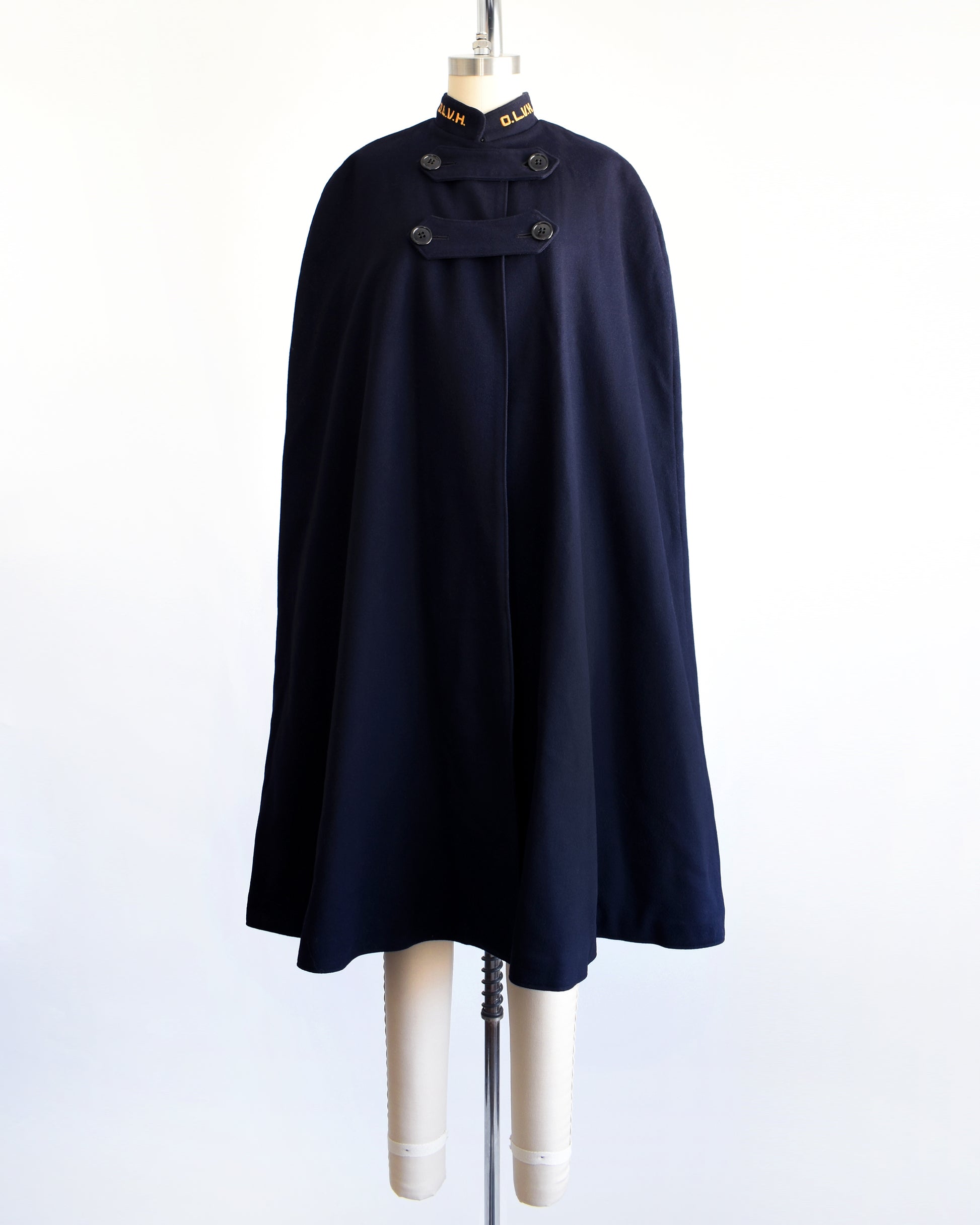 a vintage 1940s navy nurse's cape on a mannequin against a white background. 