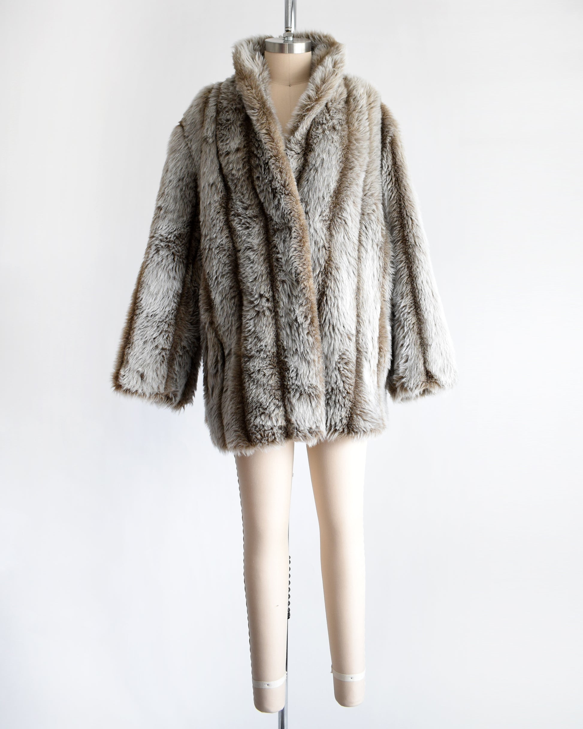 a vintage 1980s brown and gray faux fur coat on a mannequin against a white background