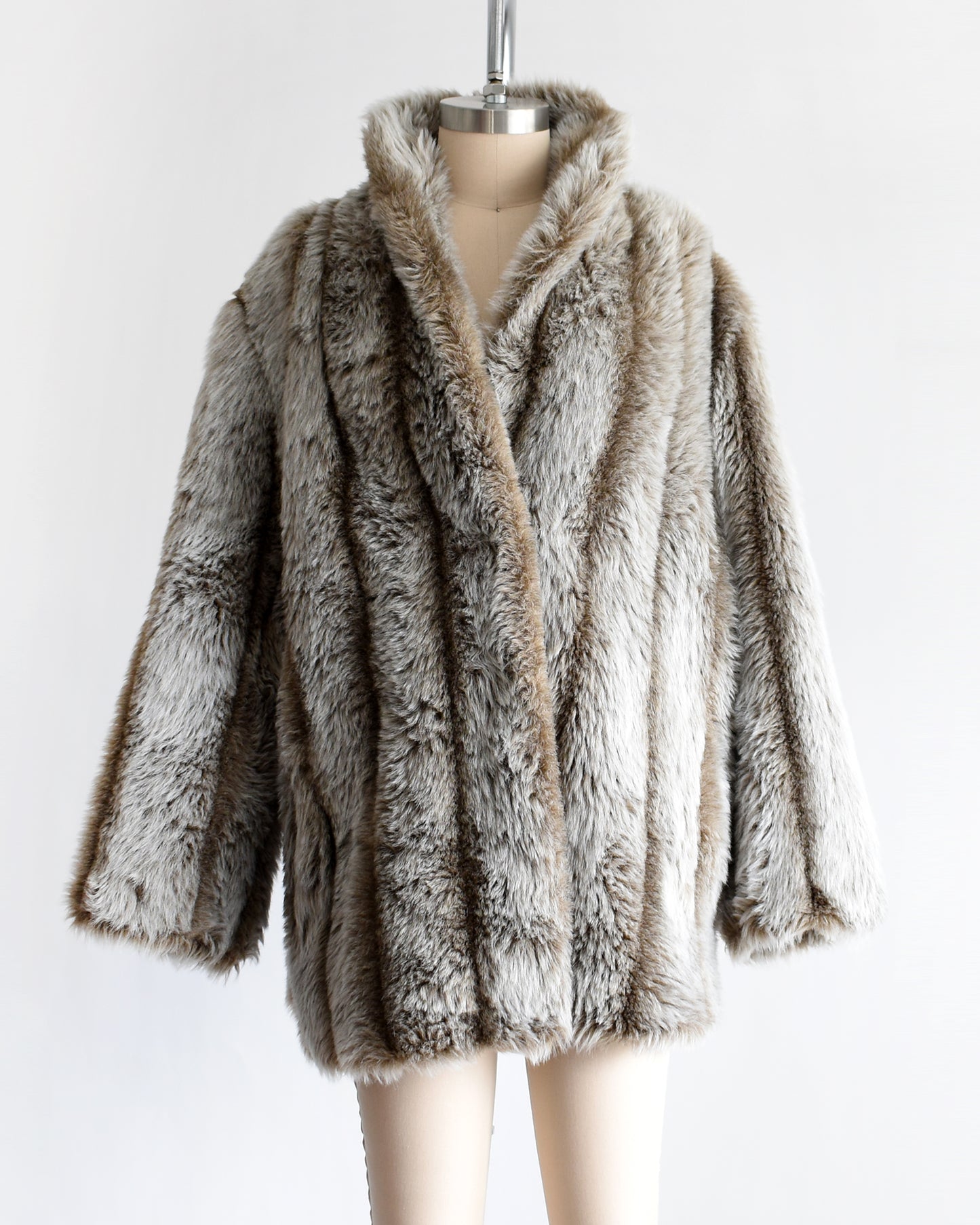 a vintage 1980s brown and gray faux fur coat on a mannequin against a white background