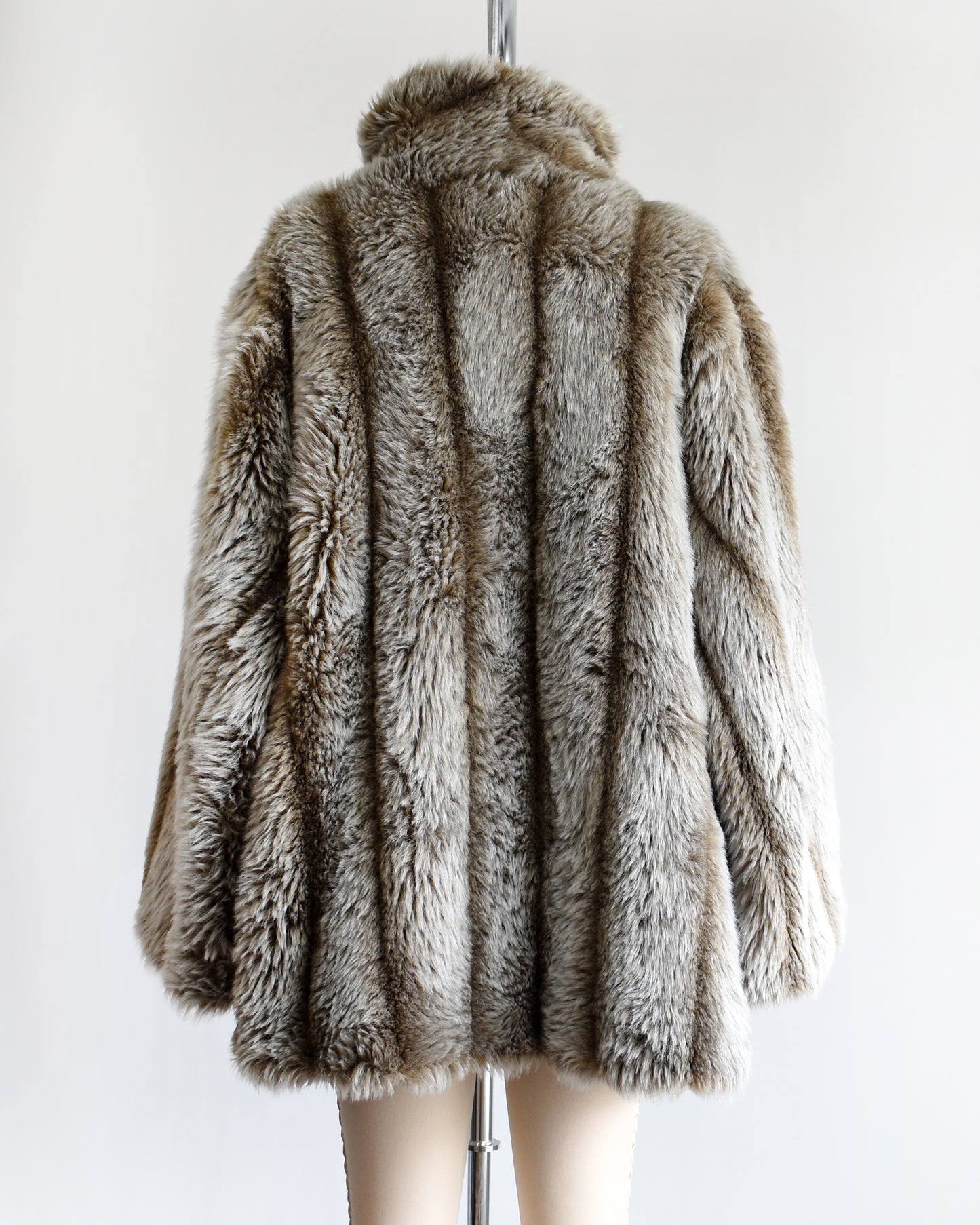 back view of a vintage 1980s brown and gray faux fur coat on a mannequin against a white background