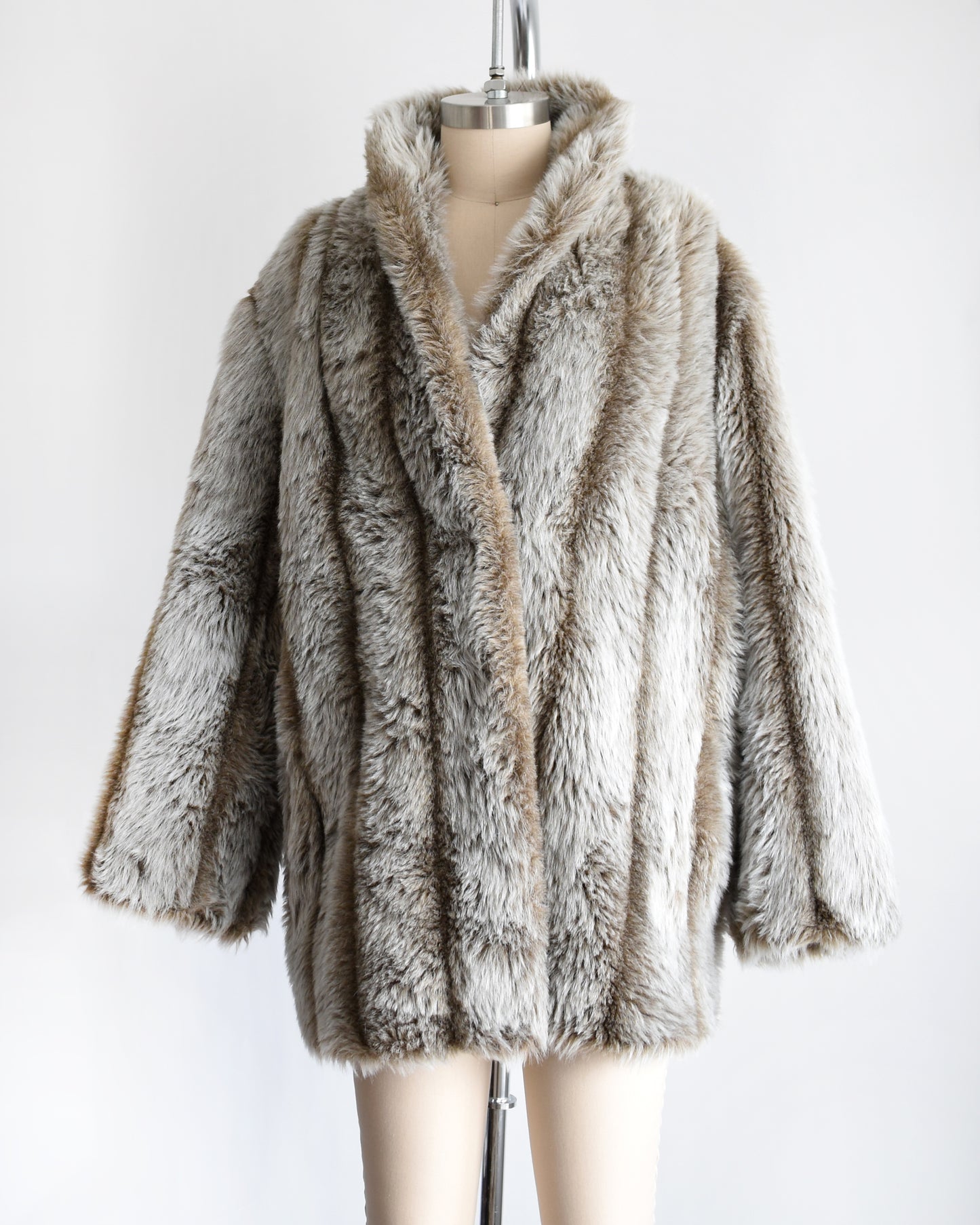 side front view of a vintage 1980s brown and gray faux fur coat on a mannequin against a white background