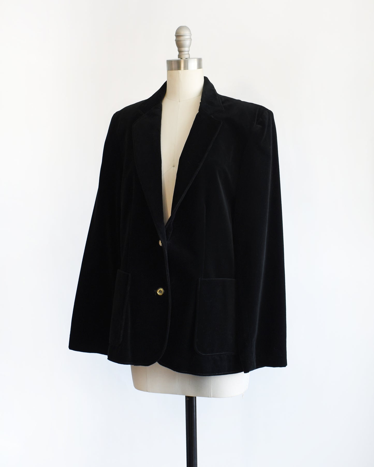 side view of a vintage 1980s black velvet  blazer on a mannequin against a white background