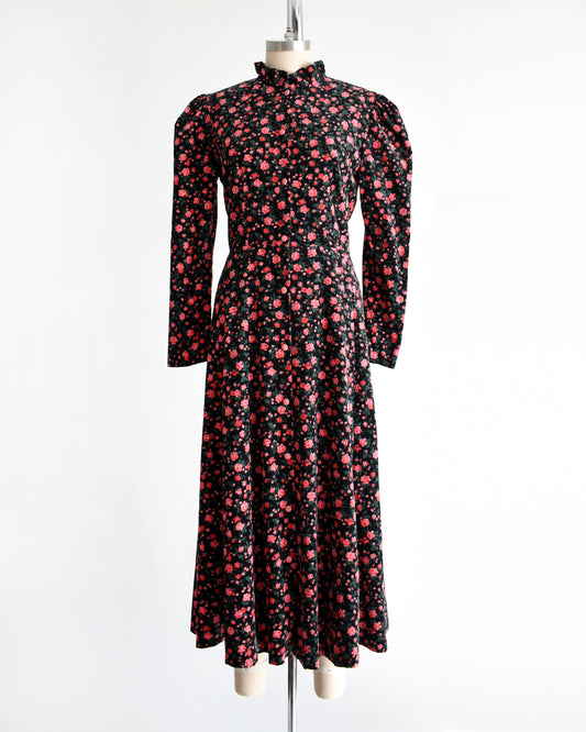 a vintage 1990s black and pink floral dress on a mannequin against a white background