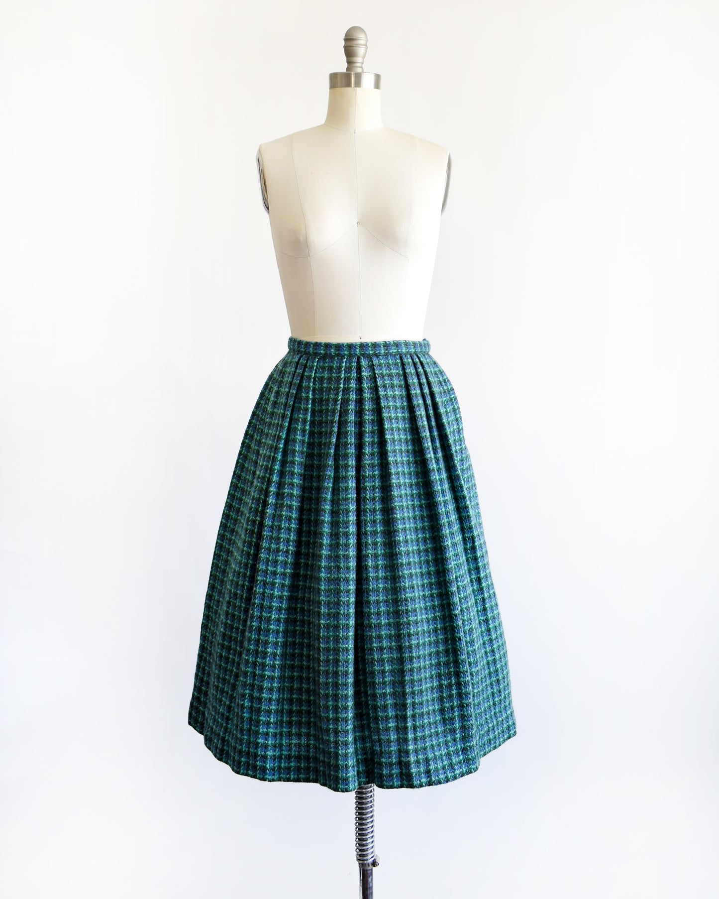 a vintage 1950s/1960s blue and green plaid skirt on a mannequin against a white background