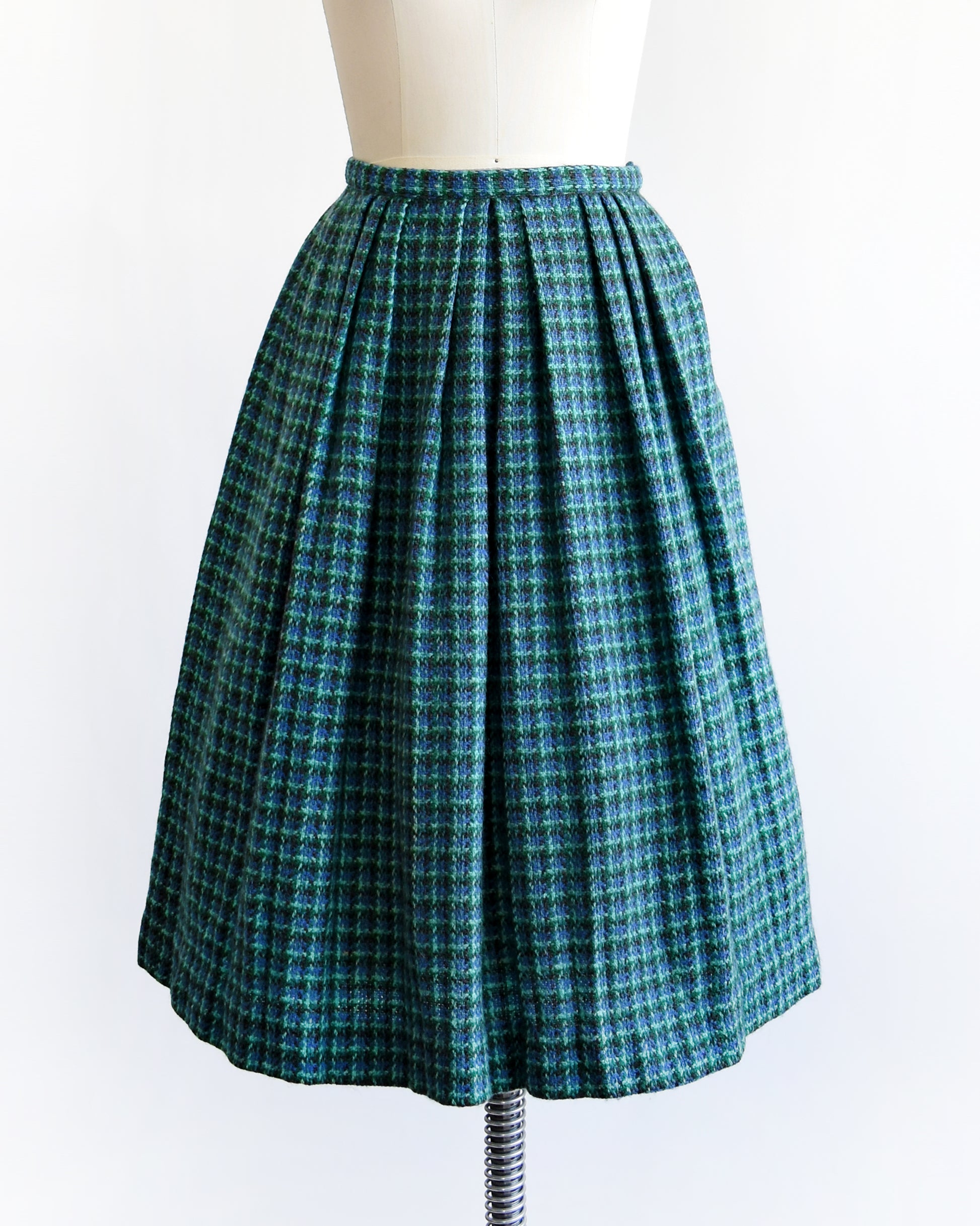 a vintage 1950s/1960s blue and green plaid skirt on a mannequin against a white background