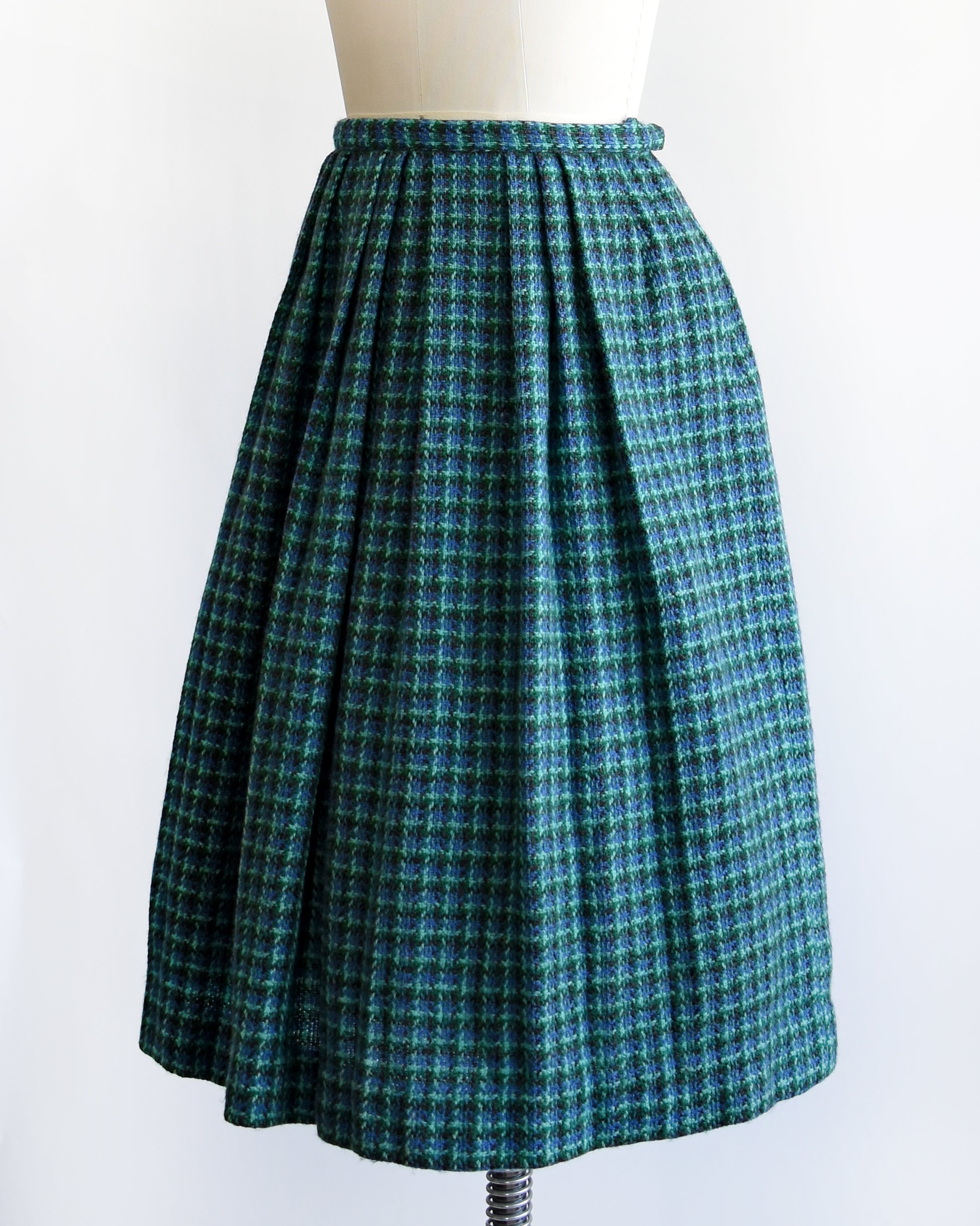 side front view of a vintage 1950s/1960s blue and green plaid skirt on a mannequin against a white background