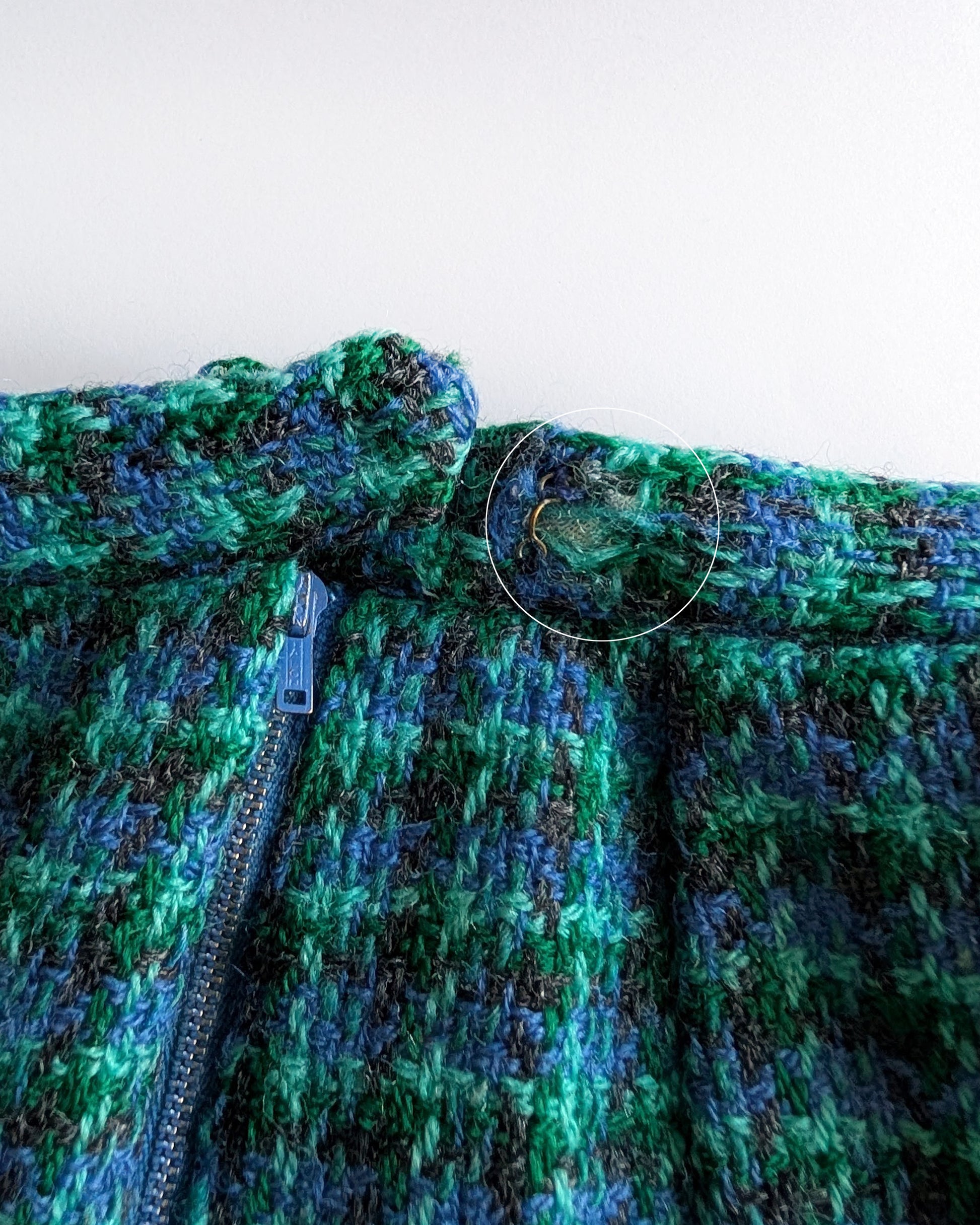 close up of a small flaw on the waist which shows a small bit of wool missing which shows the inner waistband.