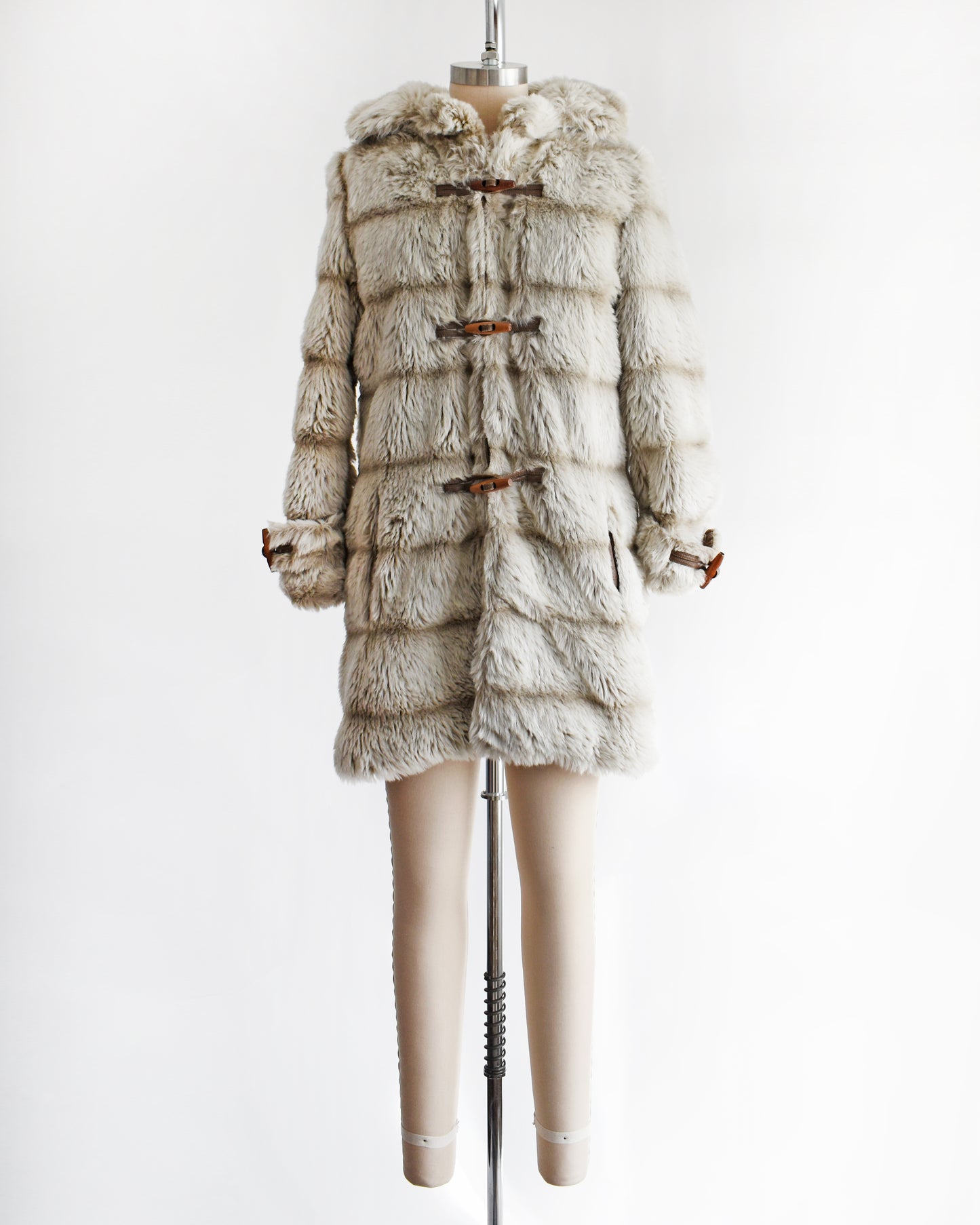 a vintage 1970s faux fur coat with hood on a mannequin against a white background