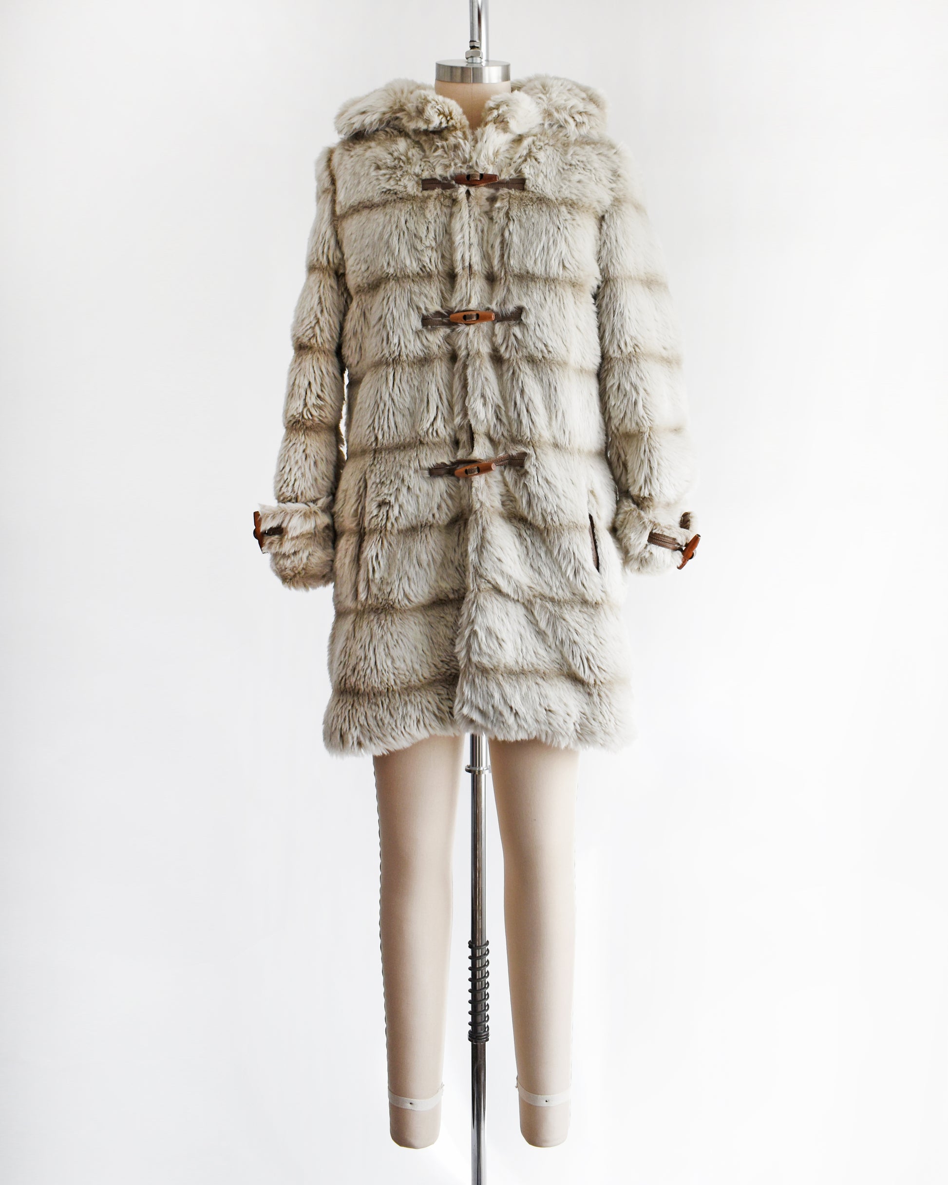 a vintage 1970s faux fur coat with hood on a mannequin against a white background