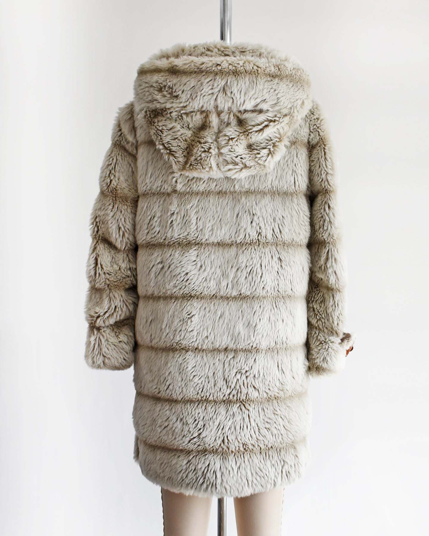 back view of a vintage 1970s faux fur coat with hood on a mannequin against a white background