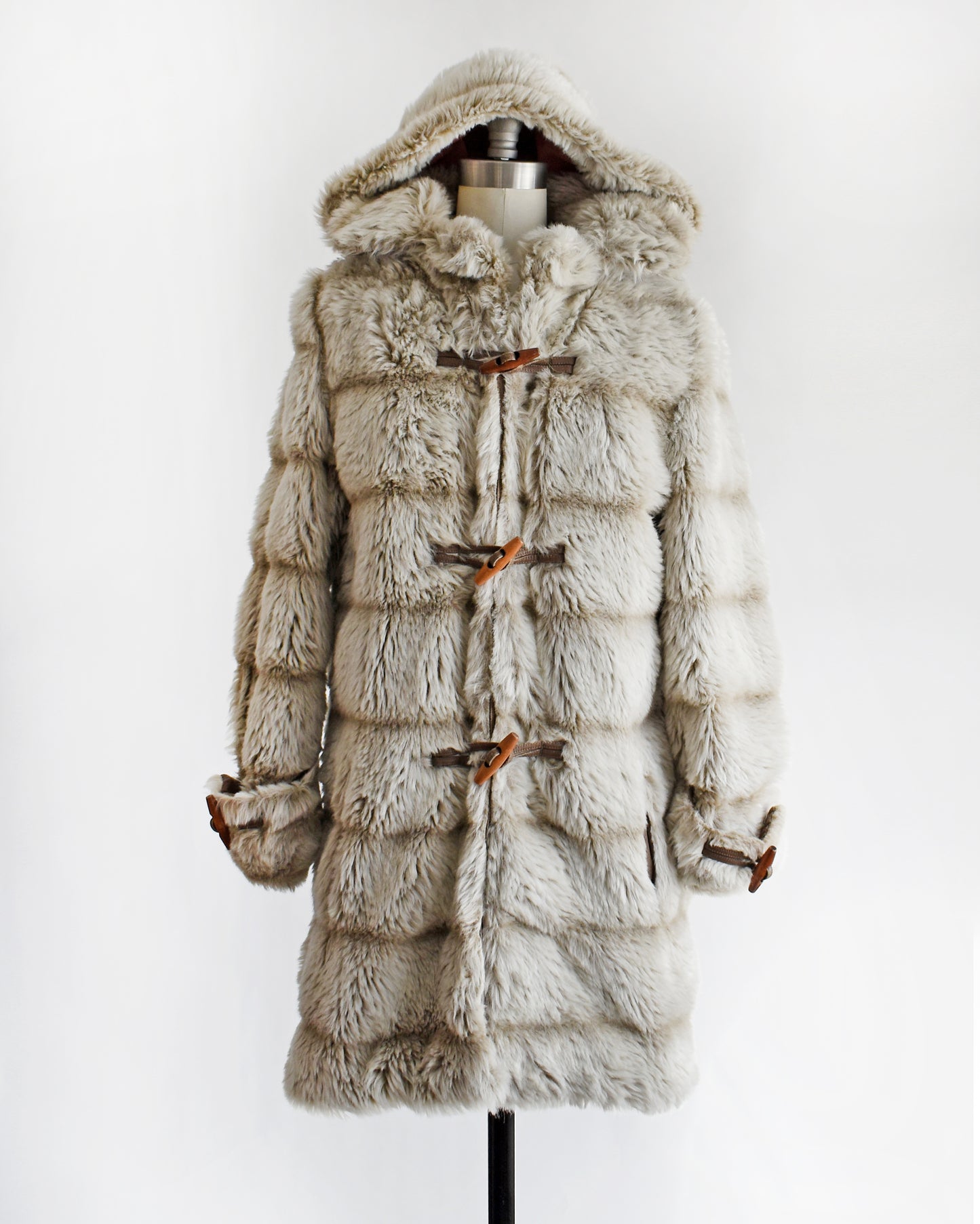 a vintage 1970s faux fur coat with hood on a mannequin against a white background