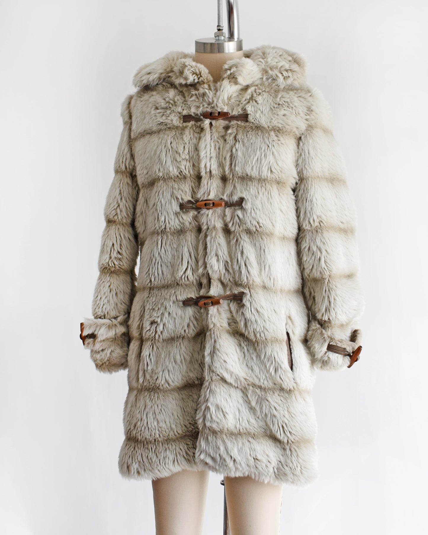 side front view a vintage 1970s faux fur coat with hood on a mannequin against a white background