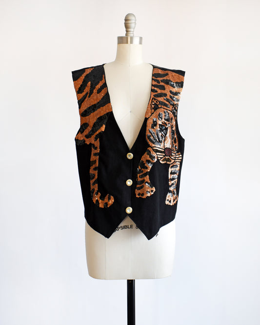 a vintage 1980s black vest with an orange sequin tiger on a mannequin against a white background
