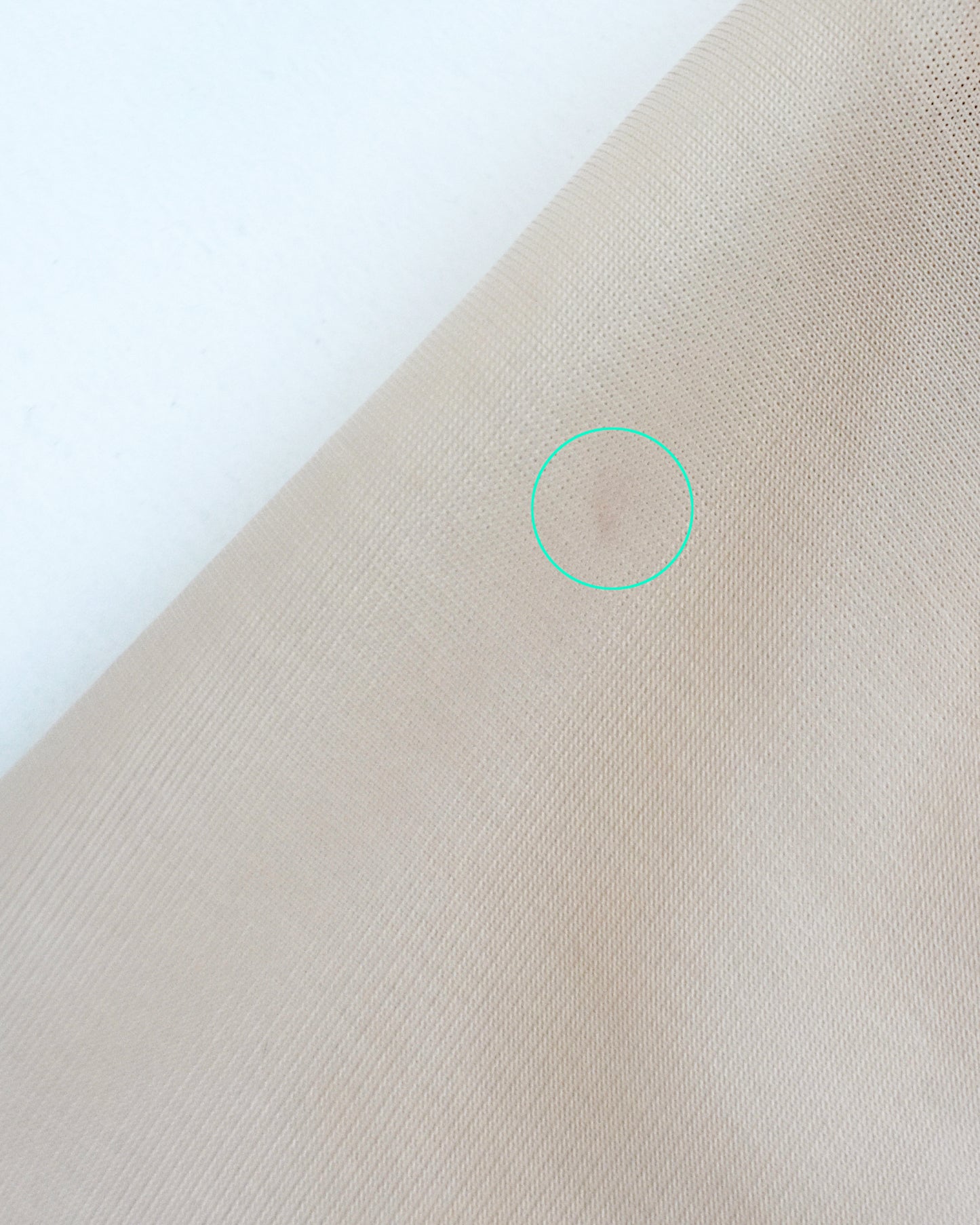 a small mark is on the back of the left short sleeve