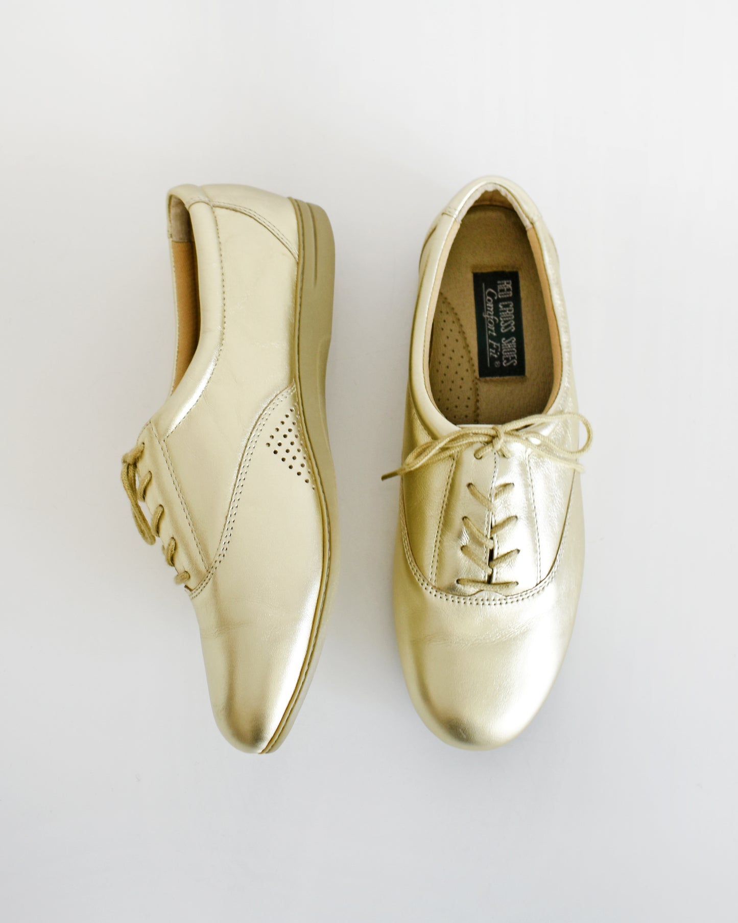 A pair of vintage metallic gold lace-up shoes, shown from both side and top-down angles on a clean white background.
