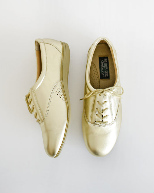 A pair of vintage metallic gold lace-up shoes, shown from both side and top-down angles on a clean white background.