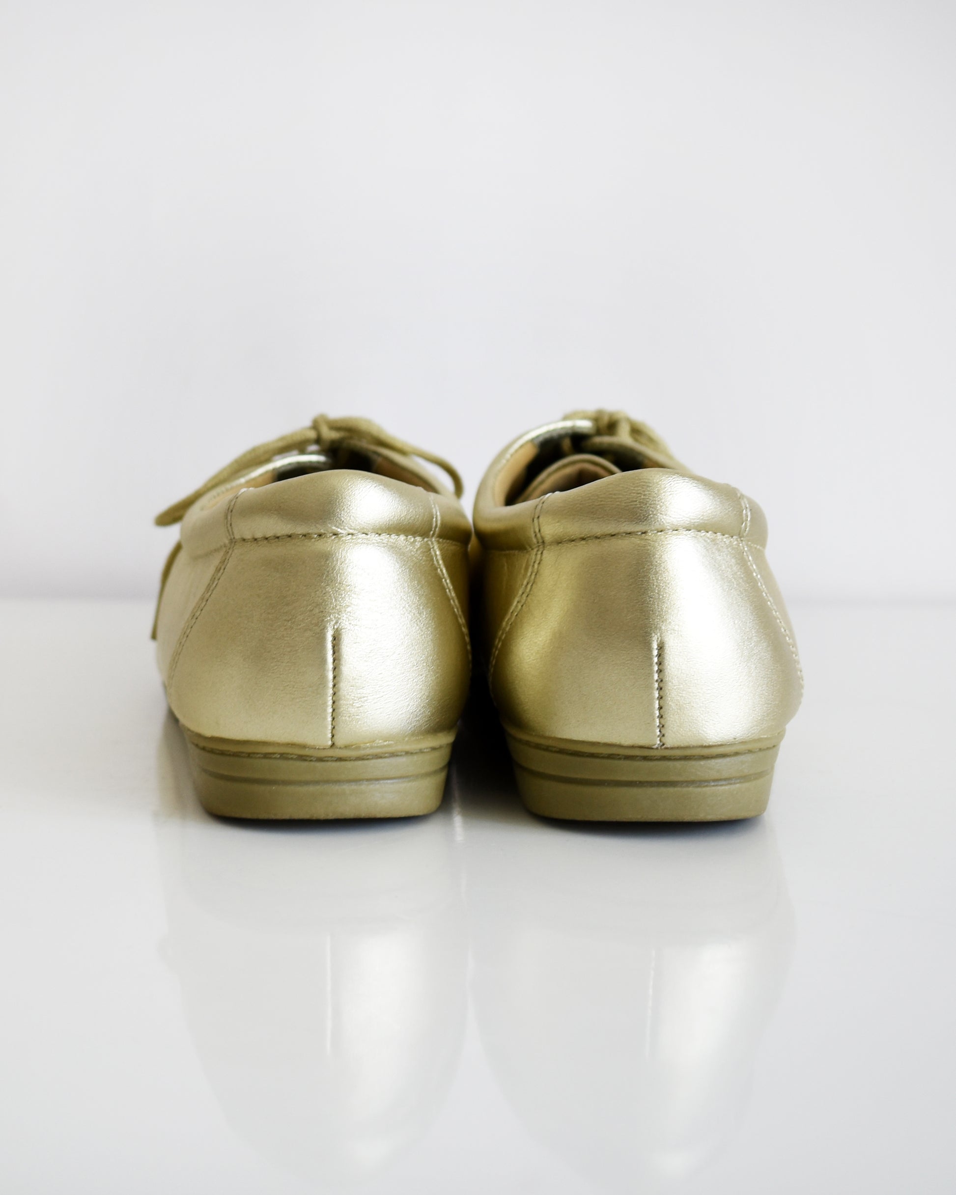 back view of a pair of vintage metallic gold lace-up shoes, shown from both side and top-down angles on a clean white background.