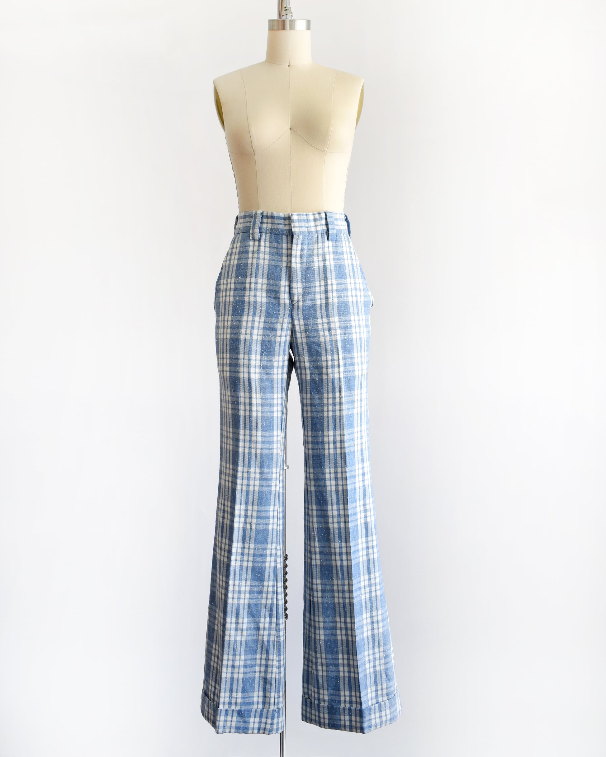vintage 1970s blue and white plaid wide-leg pants displayed on a cream dress form mannequin against a plain white background.