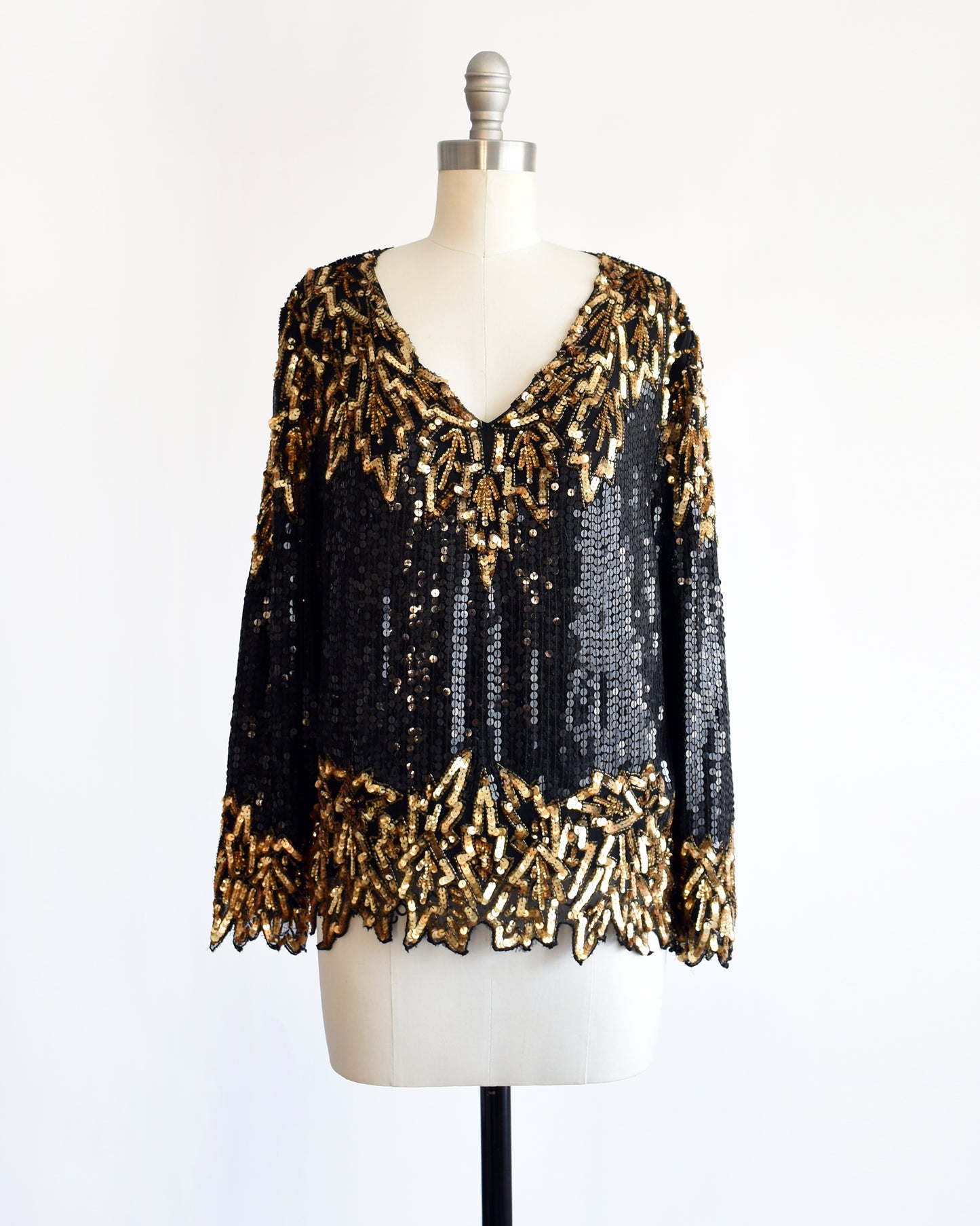 a vintage 1980s black and gold sequin top on a mannequin against a white background