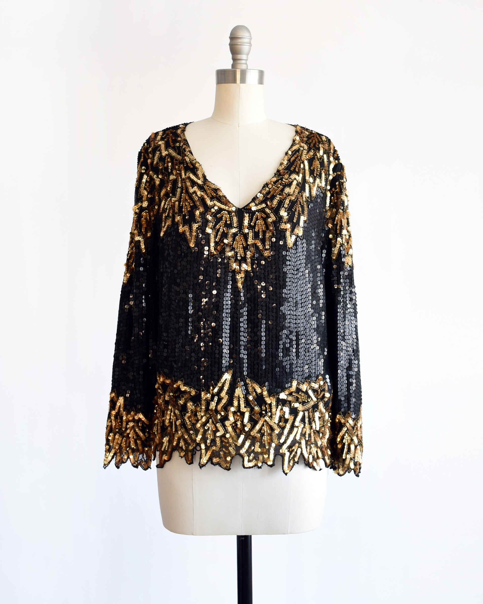 a vintage 1980s black and gold sequin top on a mannequin against a white background