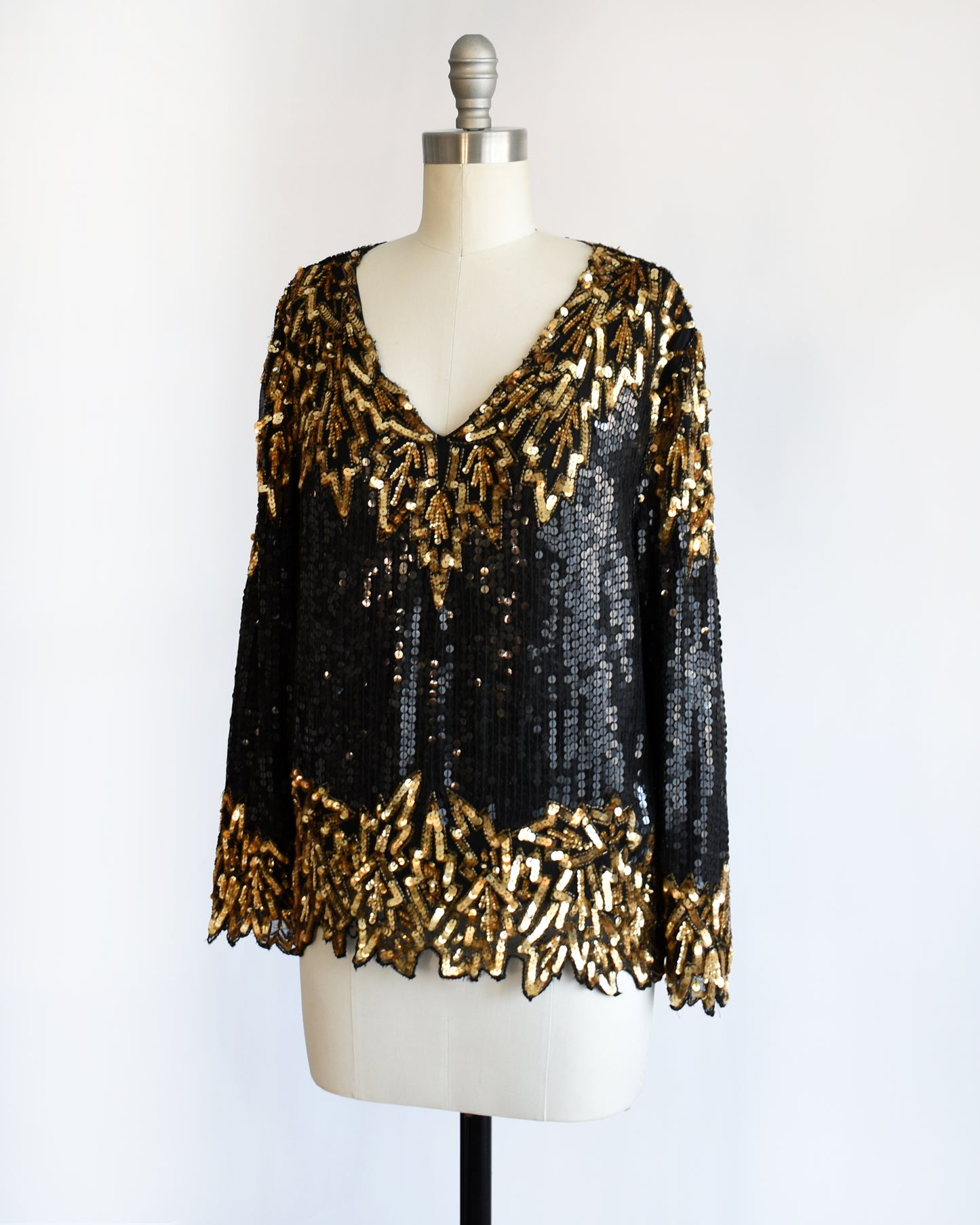 side front view of a vintage 1980s black and gold sequin top on a mannequin against a white background