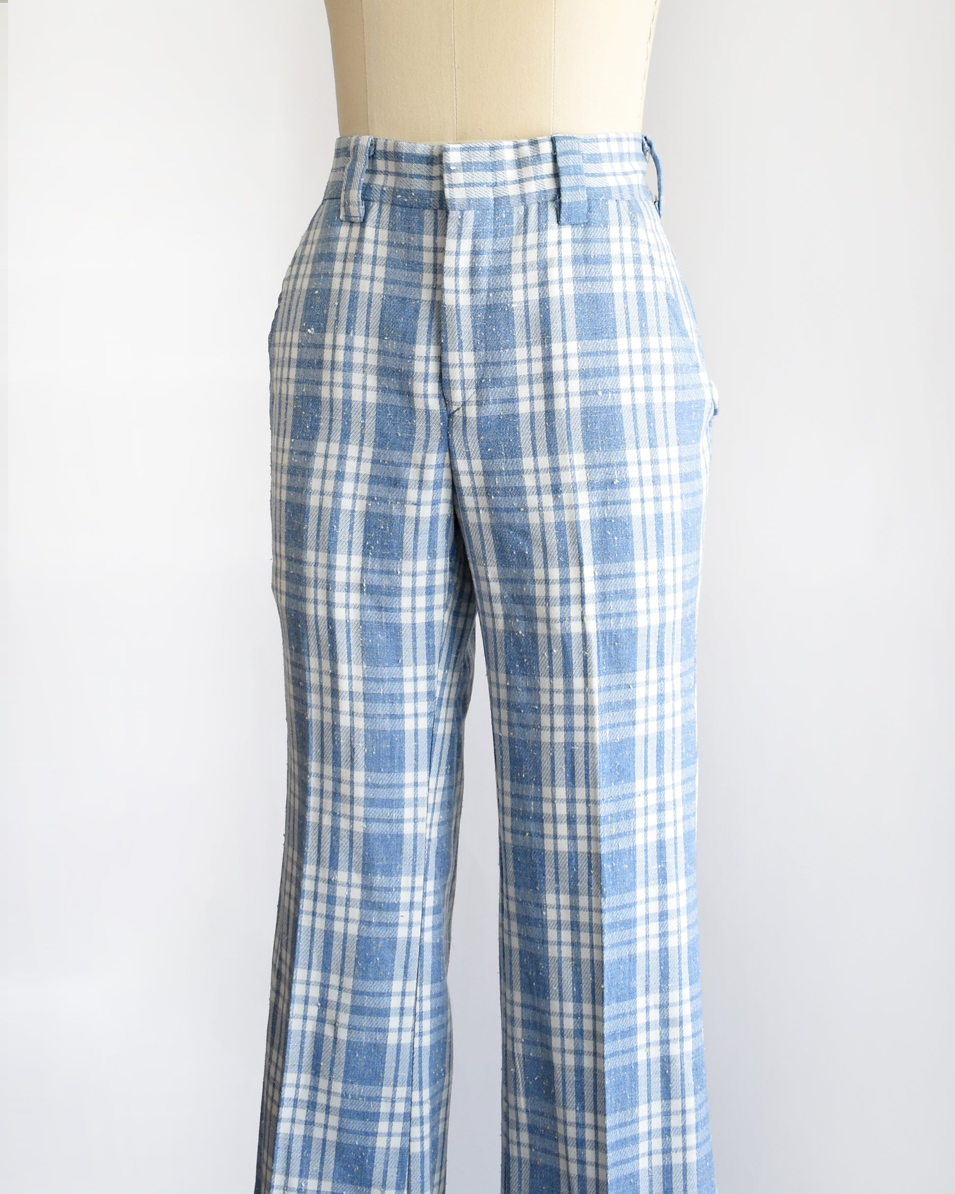 side front view of vintage 1970s blue and white plaid wide-leg pants displayed on a cream dress form mannequin against a plain white background.