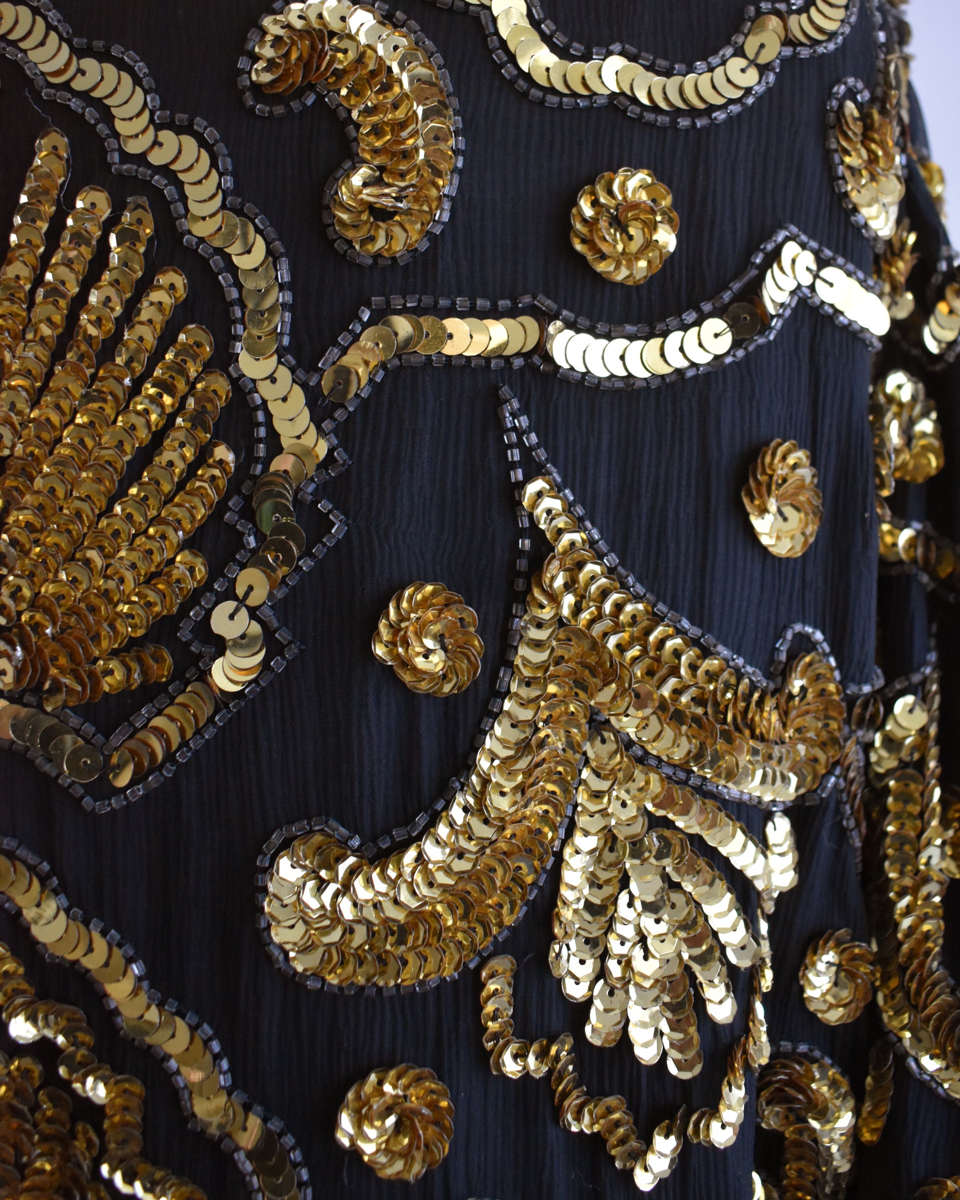 Close-up of a black fabric with gold sequin embellishments