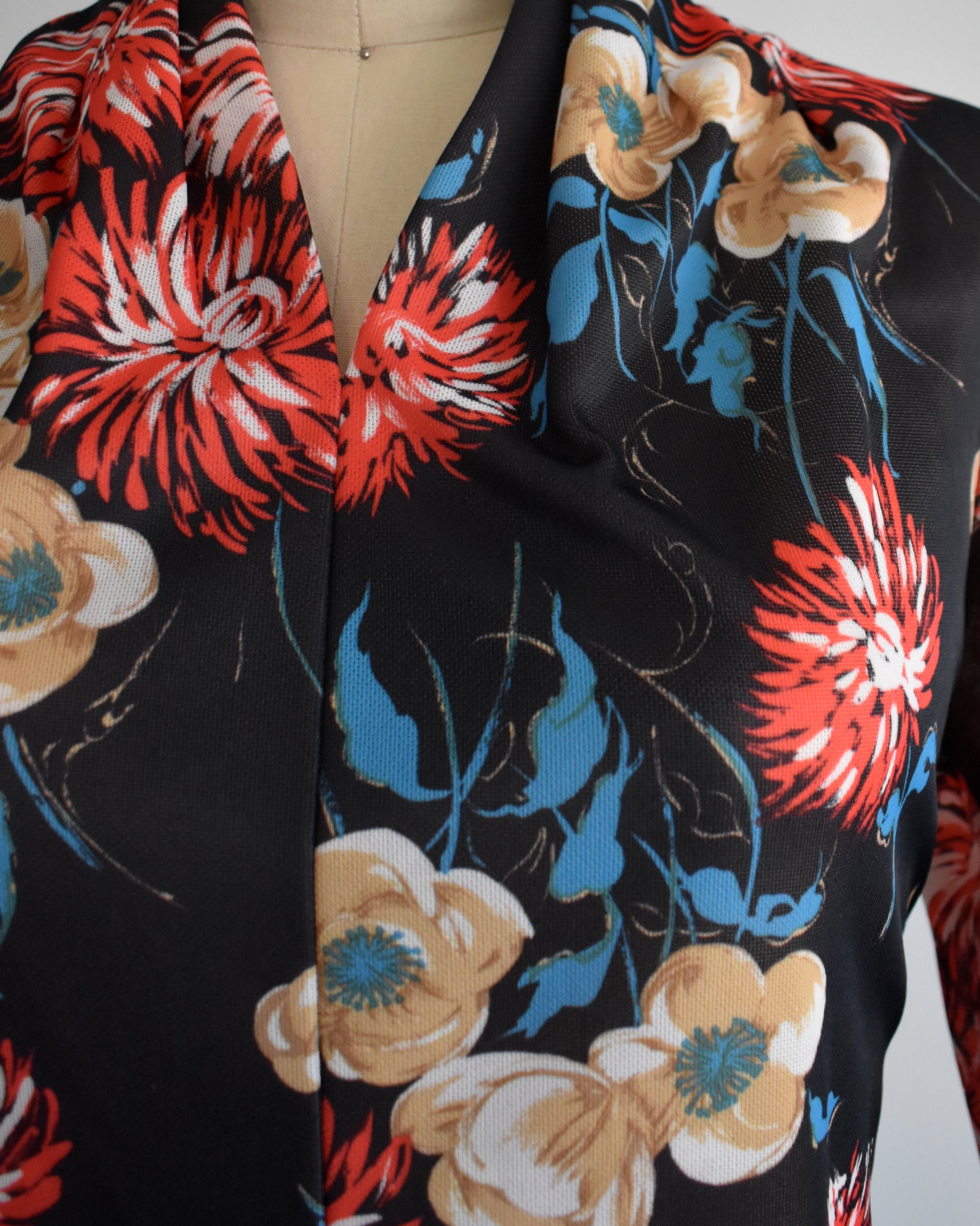 close up of the bodice of the dress which shows the large floral pattern and v-neckline.