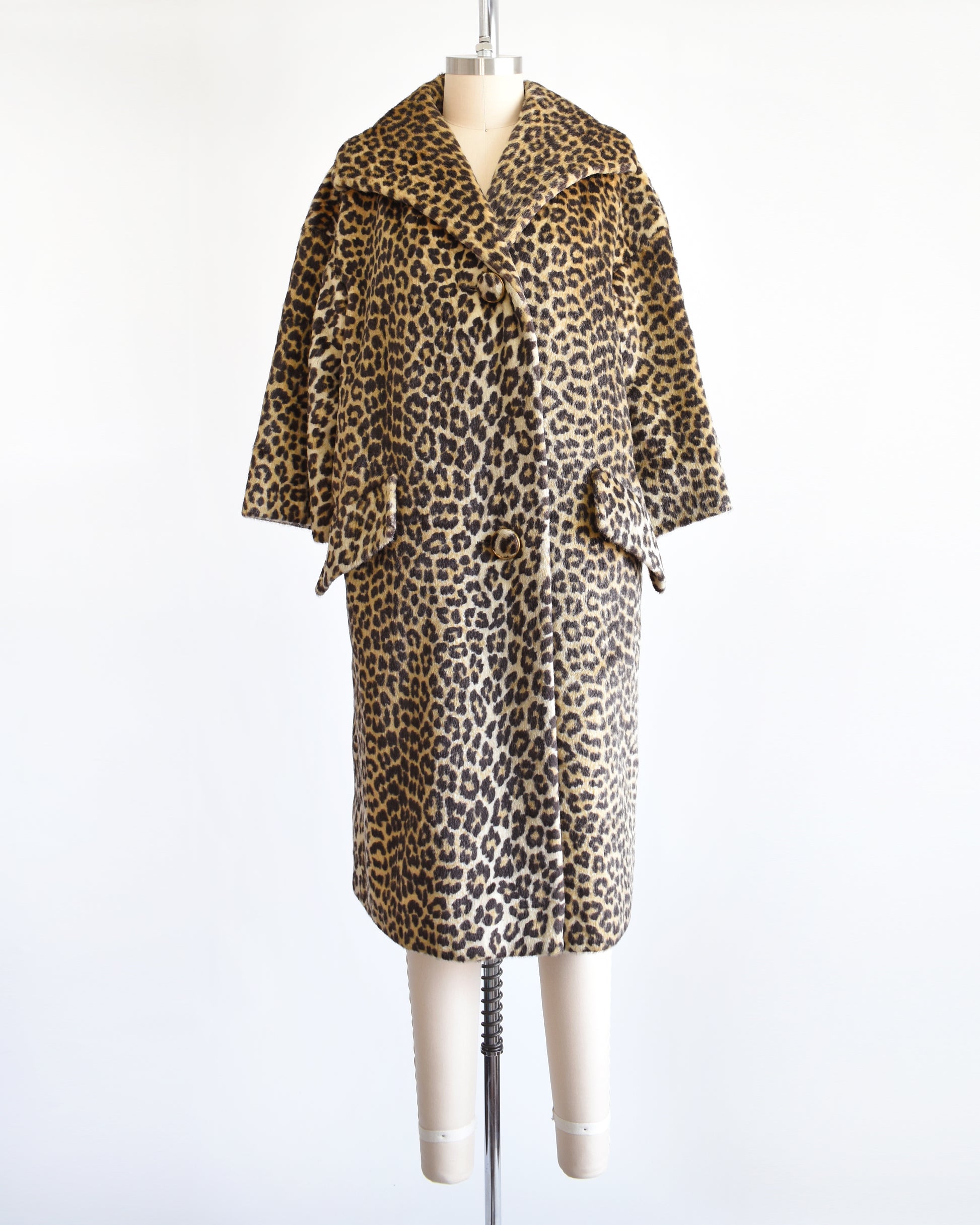 A vintage 1960s faux fur leopard print coat on a dress form