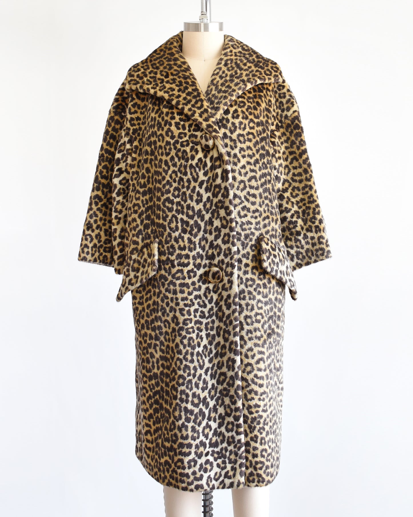 A vintage 1960s faux fur leopard print coat on a dress form