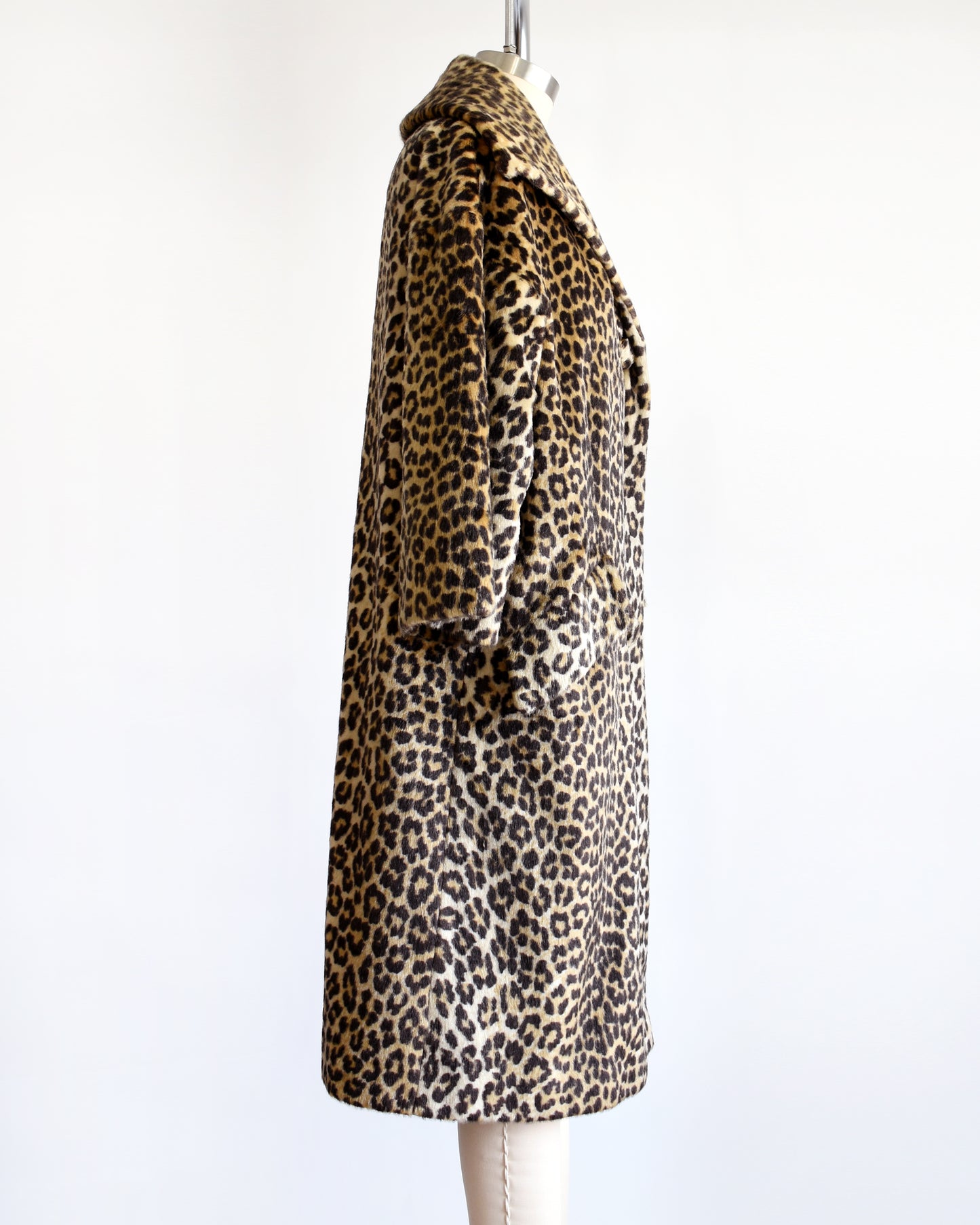 Side view of a vintage 1960s faux fur leopard print coat on a dress form